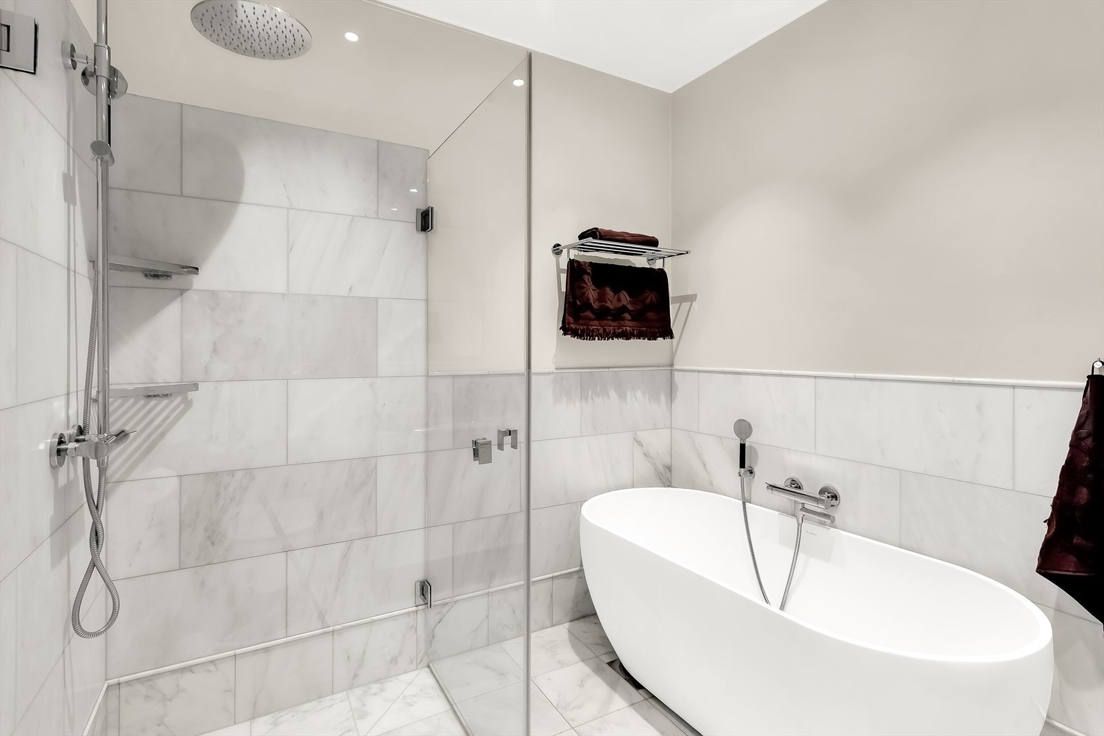 Badet har en romslig dusj med glassvegg og regnfallsdusj, samt et frittstående badekar - godt egnet for avslapning hjemme. Galleribilde