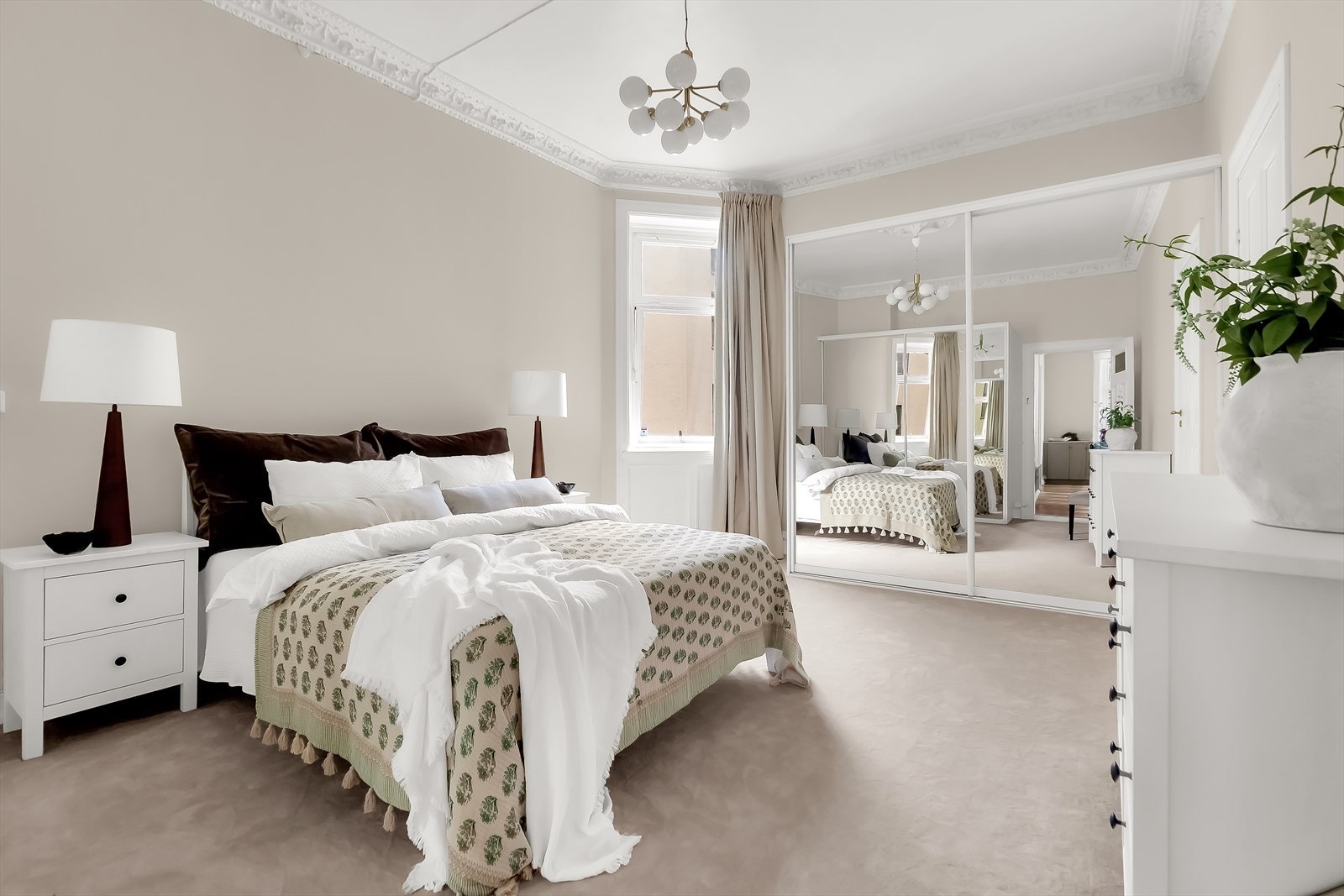 Hovedsoverommet er romslig, med plass til dobbeltseng, nattbord og øvrige møbler. Vegg-til-vegg-teppet i en lun beige tone sammen med stukkatur gir rommet varme og karakter. Galleribilde