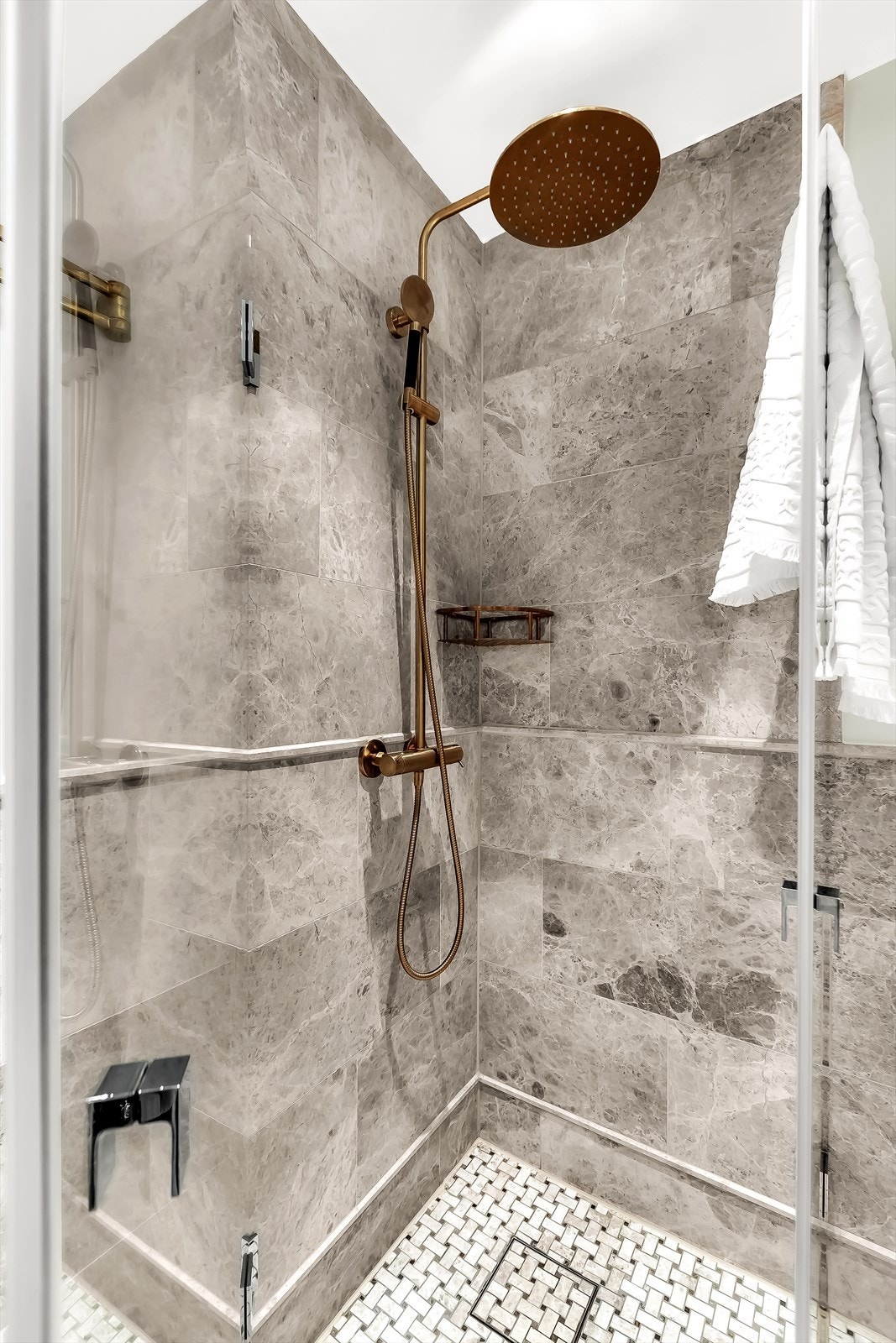 Dusjsonen er avgrenset med stilren glassvegg og utstyrt med regnfallsdusj og armatur i børstet messing, som skaper en luksuriøs spa-følelse. Galleribilde