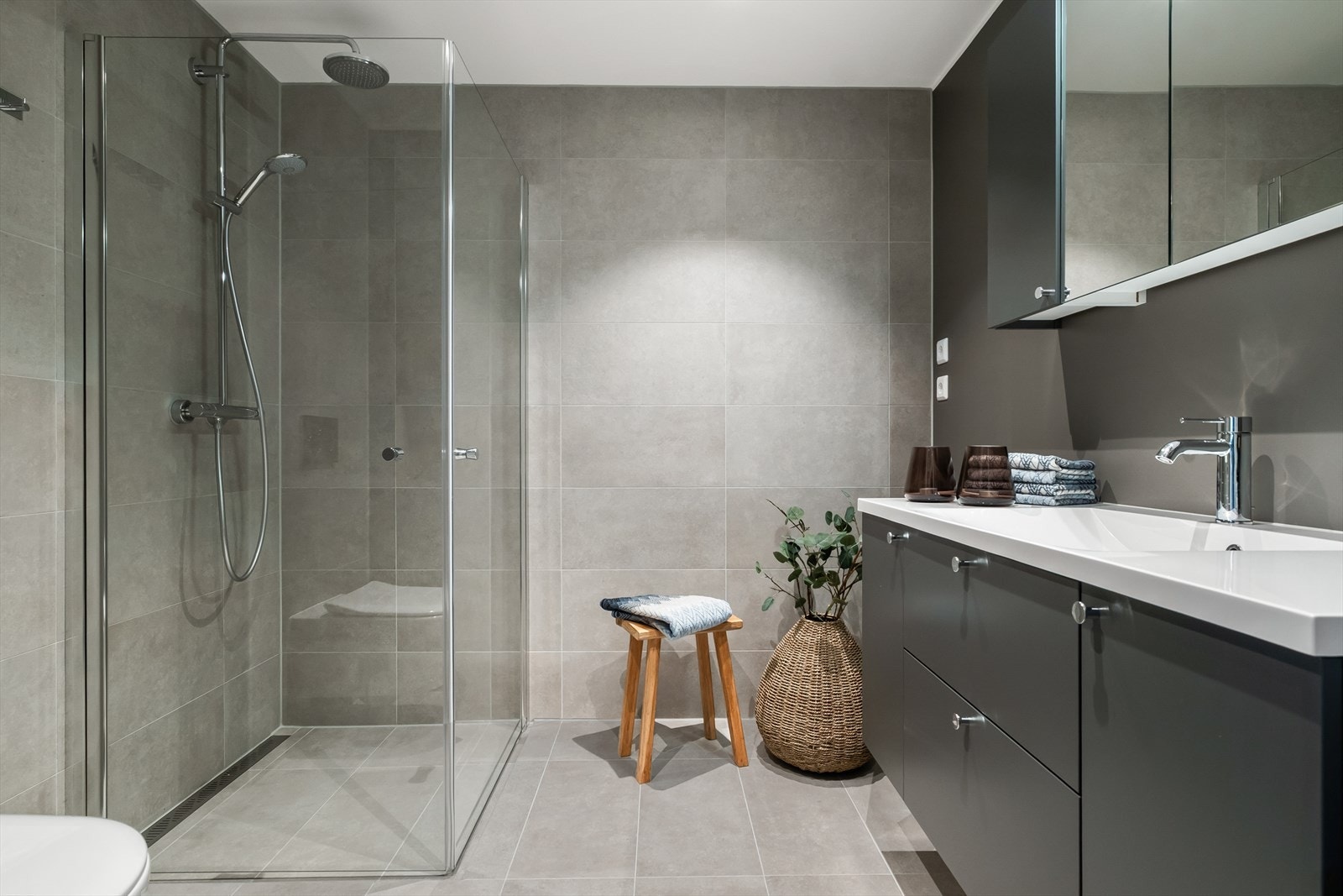 Badet har en moderne og lekker finish med flislagt gulv og delvis flislagte vegger Galleribilde