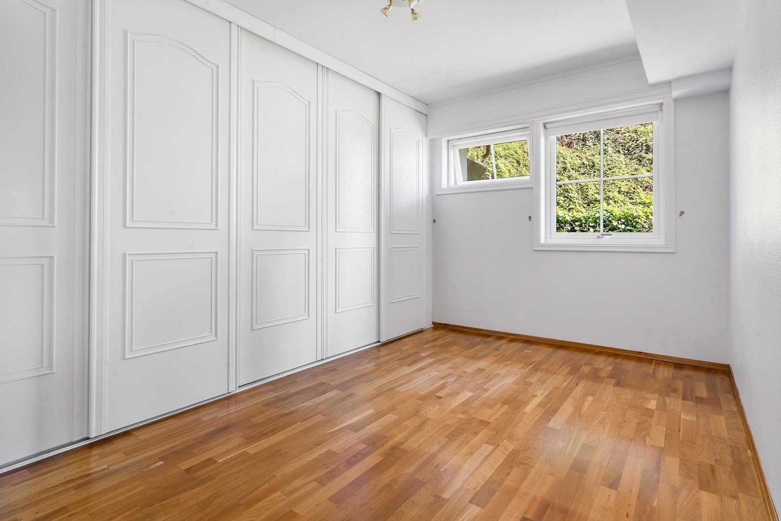 Her er hele veggen dekket av skyvedørsgarderobe til oppbevaring av ytterklær. Galleribilde