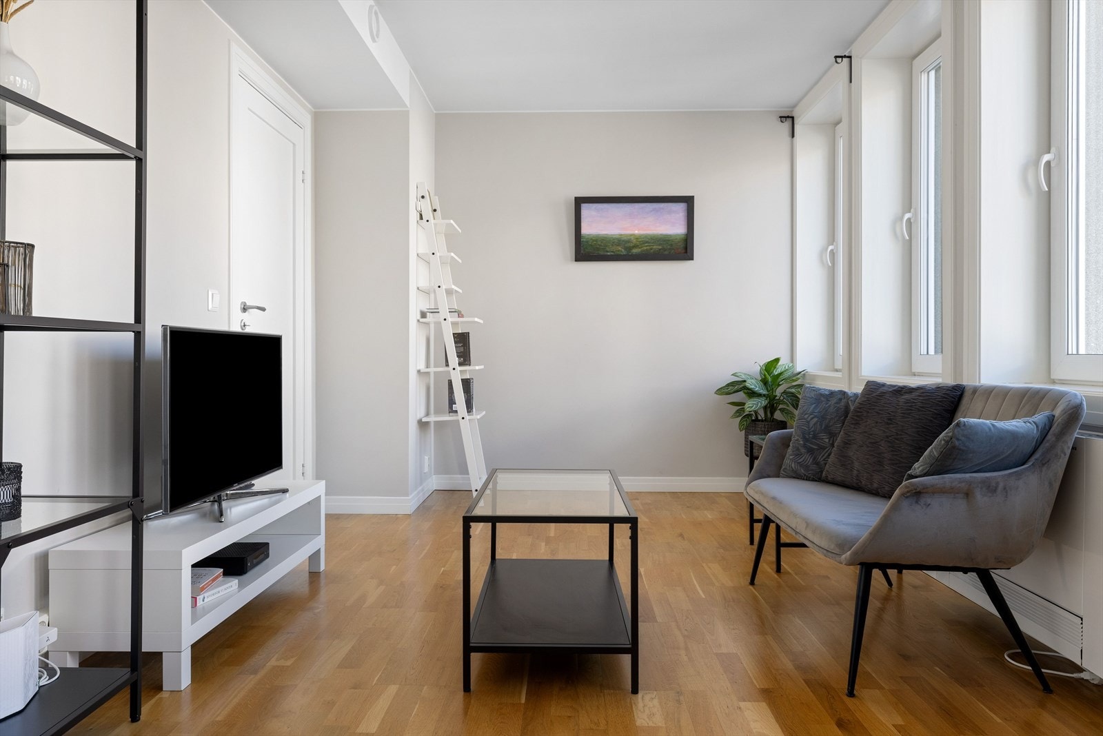 Stua er lys og åpen med lange vinduer som slipper inn rikelig med dagslys. Galleribilde