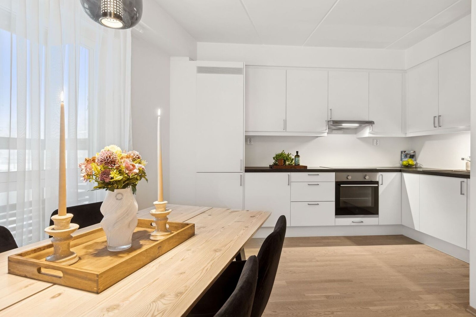 Pent kjøkken med god skap- og benkeplass, integrerte hvitevarer og praktisk tilknytning til spiseplassen. Galleribilde