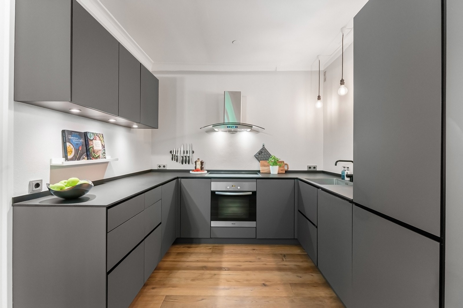 Innredningen har mørke, glatte folierte fronter og benkeplate med underlimt vaskekum. Galleribilde