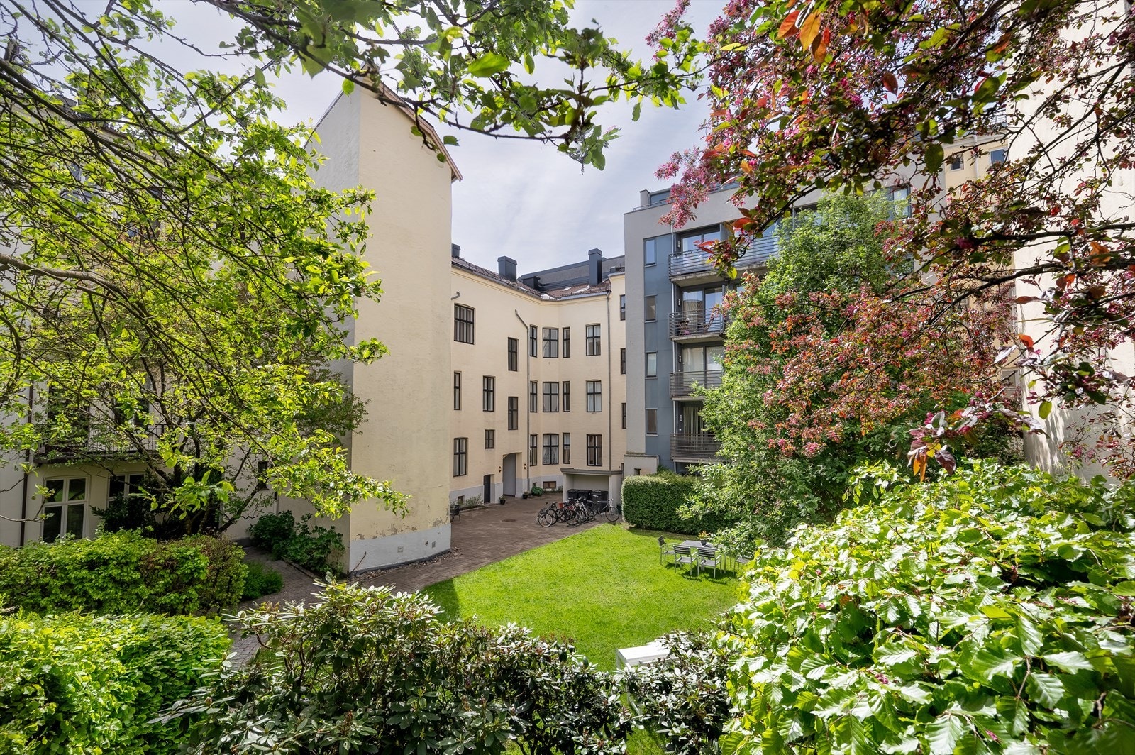Bakgården er pent opparbeidet med plen, beplantninger og sittegrupper. Galleribilde