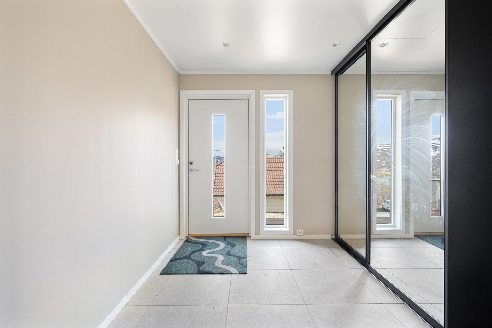 Velkommen inn! Romslig entré med lekre fliser på gulv, gulvvarme og stor skyvedørsgarderobe.