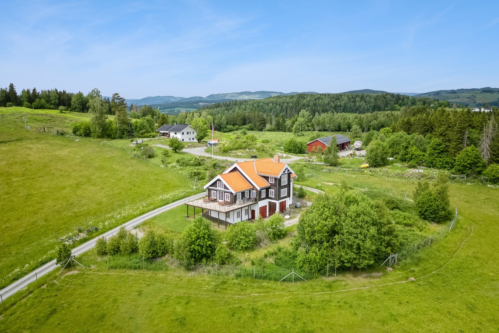 Gårdsbebyggelsen er plassert på en høyde i terrenget, driftsbygningen i forgrunnen og våningshus og redskapshus lenger bak Galleribilde