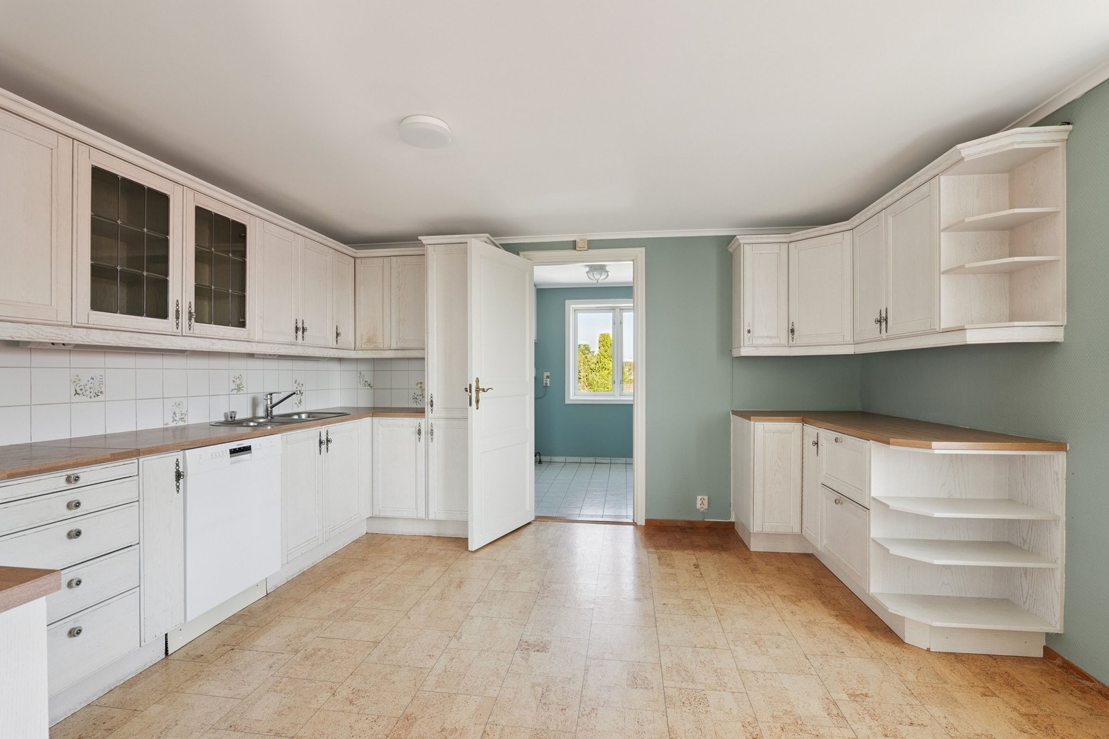 Romslig kjøkken med dør til vaskerom og kjølerom Galleribilde