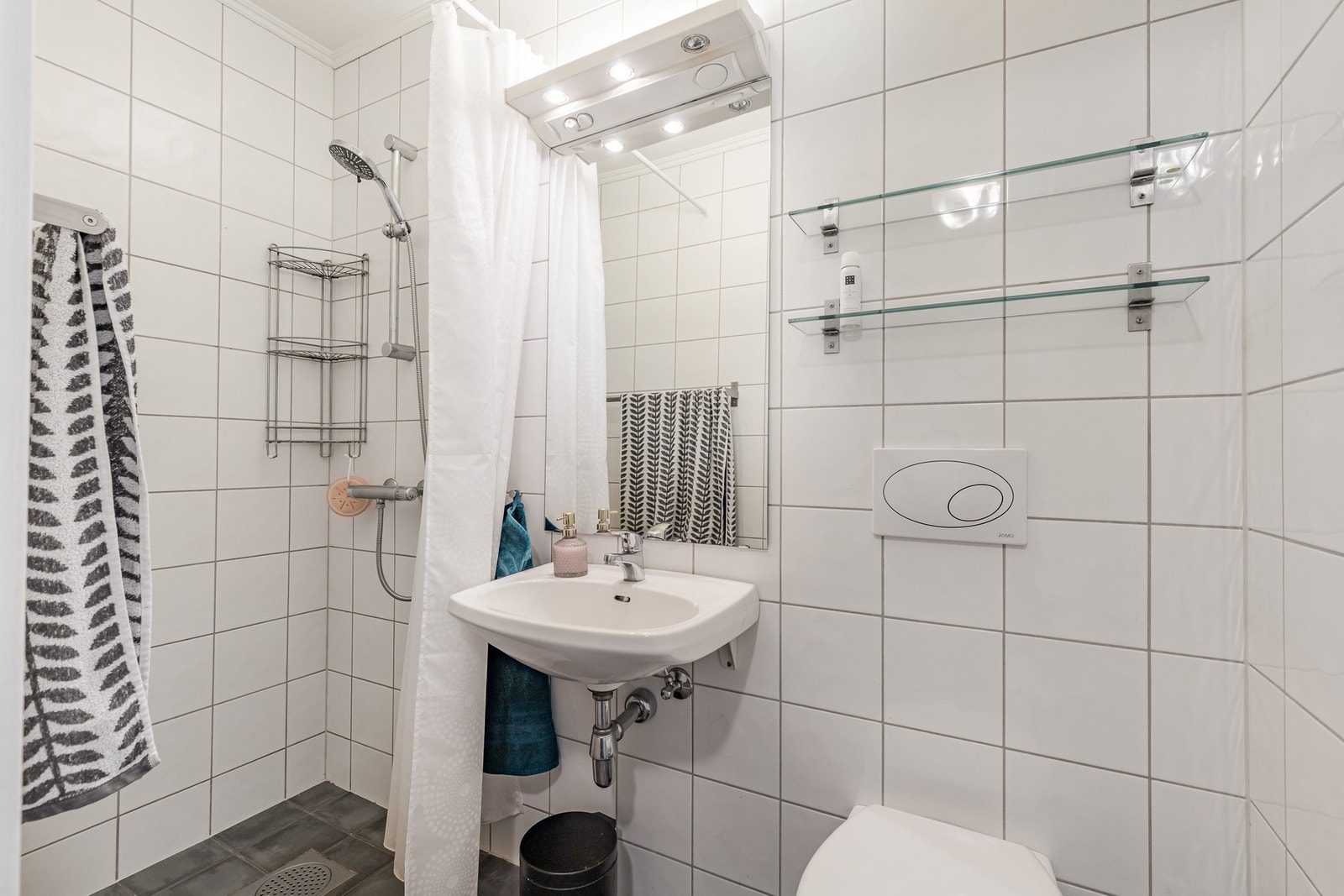 Boligen har to lyse og funksjonelle bad, ett i hver etasje. Badet i 1. etasje er flislagt og praktisk plassert ved entréen, innredet med dusjhjørne, servant og toalett samt behagelig gulvvarme. Galleribilde