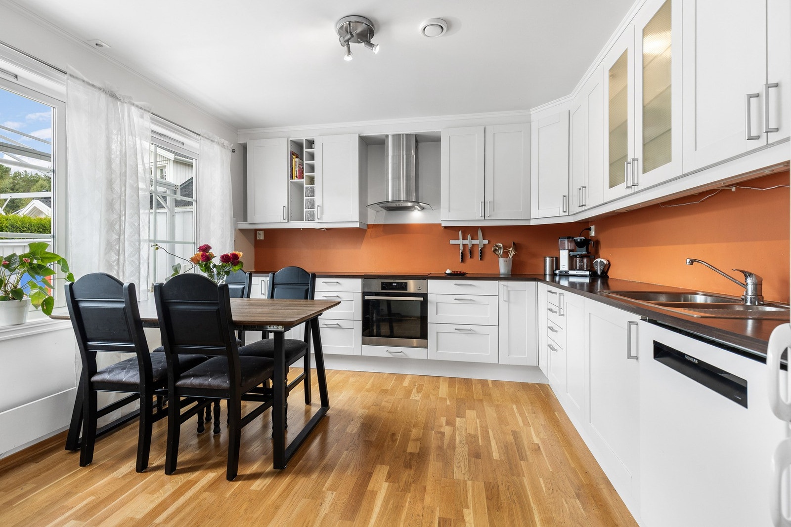 Kjøkkenet fremstår lyst og innbydende med store vindusflater som gir rikelig med naturlig lys og utsikt mot hagen. Galleribilde