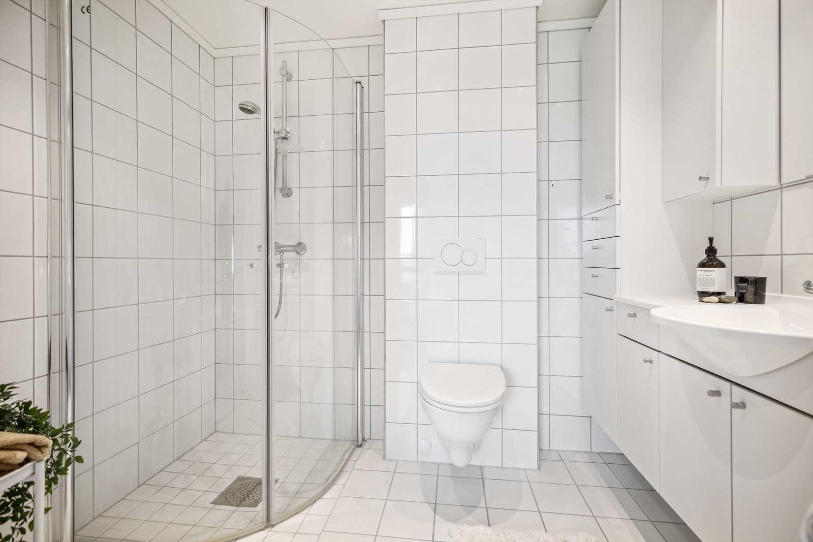 Badet i tilknytning til hovedsoverommet er flislagt med vannbåren gulvvarme, dusjhjørne med svingbare glassdører, vegghengt toalett og servantinnredning. Galleribilde