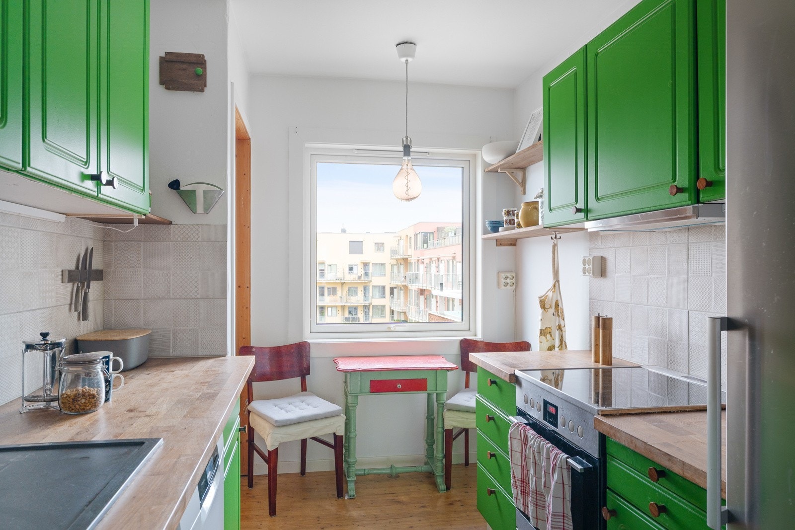 Kjøkkenet strekker seg på to sider av rommet - en løsning som allikevel gjør det mulig å møblere med spisebord i nærhet til vindu. Galleribilde