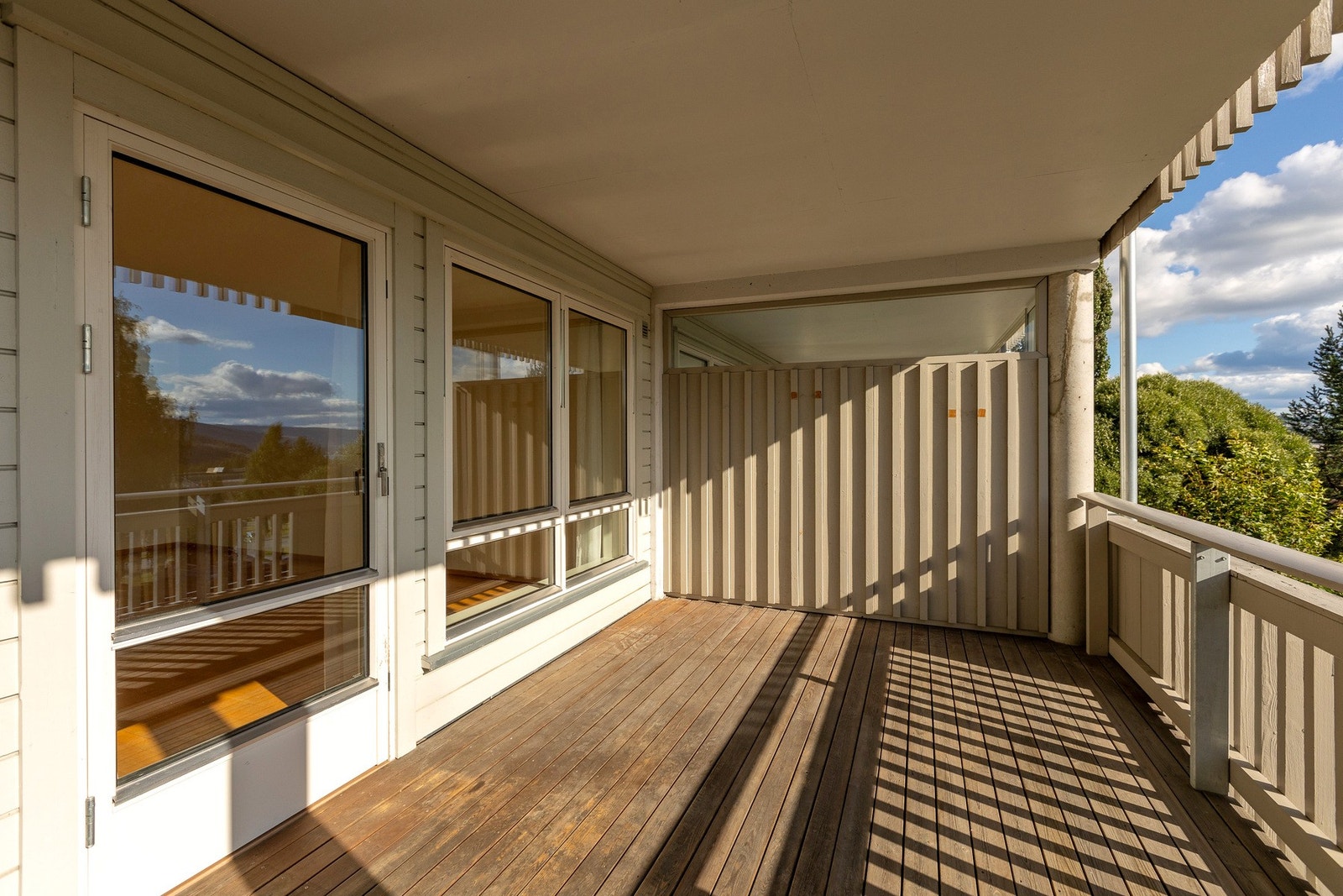 Romslig terrasse med tredekke og god plass til sittegruppe og planter - perfekt for sosiale stunder. Galleribilde