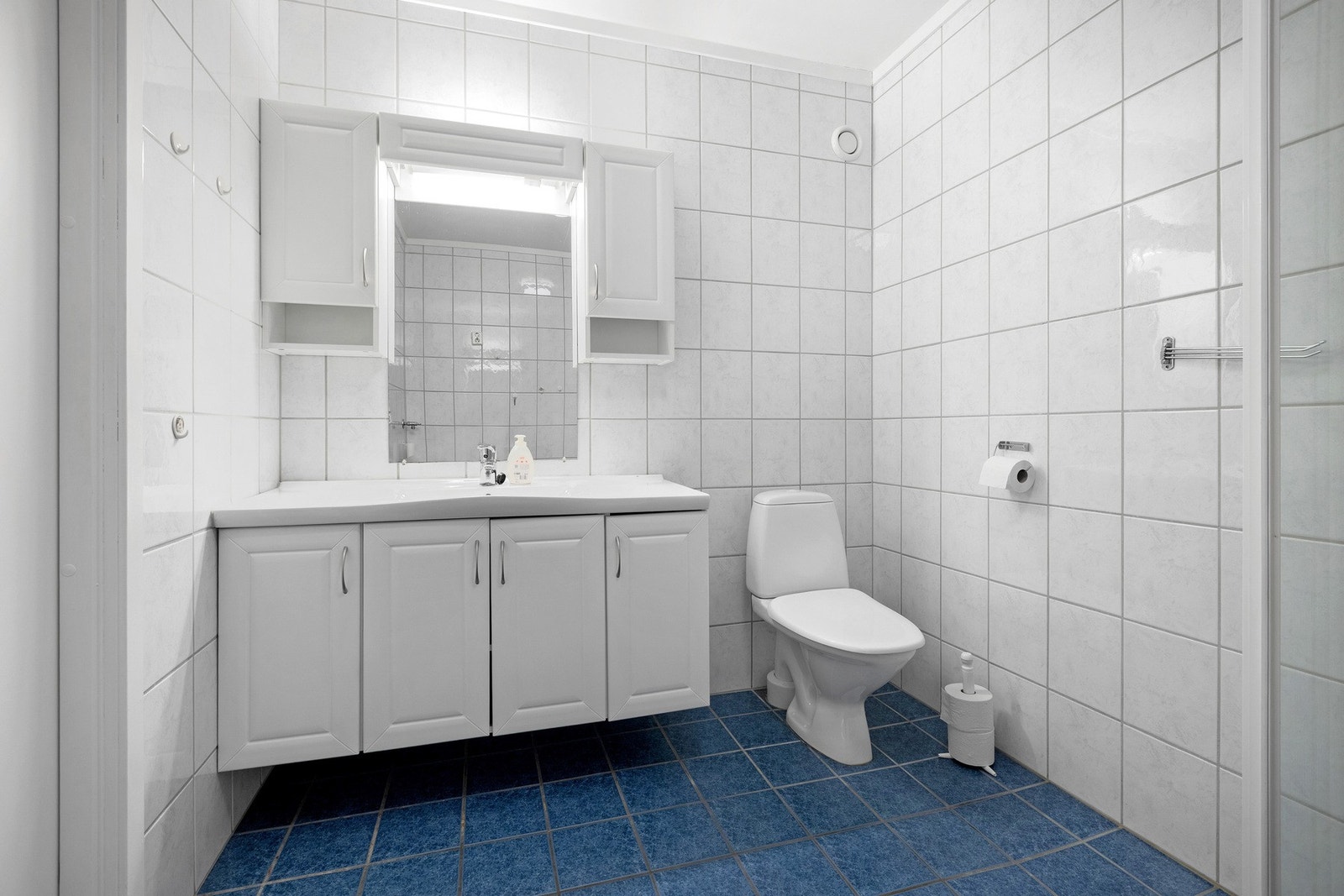 Lyst og romslig bad med flislagte flater, moderne innredning og gulvvarme for ekstra komfort. Galleribilde