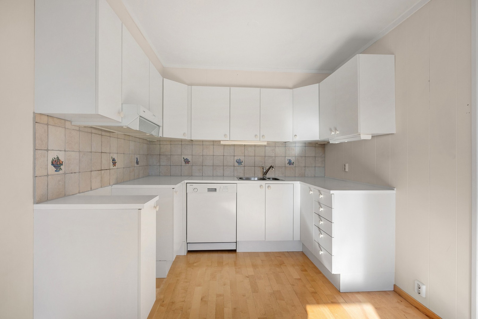 Kjøkken med hvite, tidløse fronter og godt med skap- og benkeplass. Galleribilde