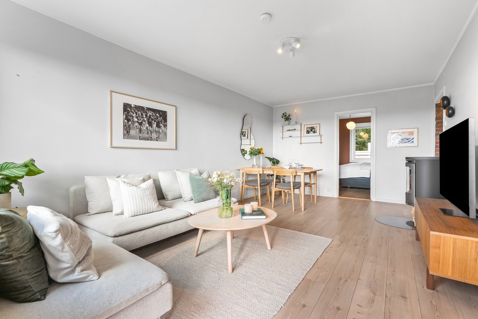 Leiligheten har en innbydende stue med plass til både spisebord og hjørnesofa. Overflatene er holdt i lyse farger og på gulvet er det enstavs laminat. Galleribilde