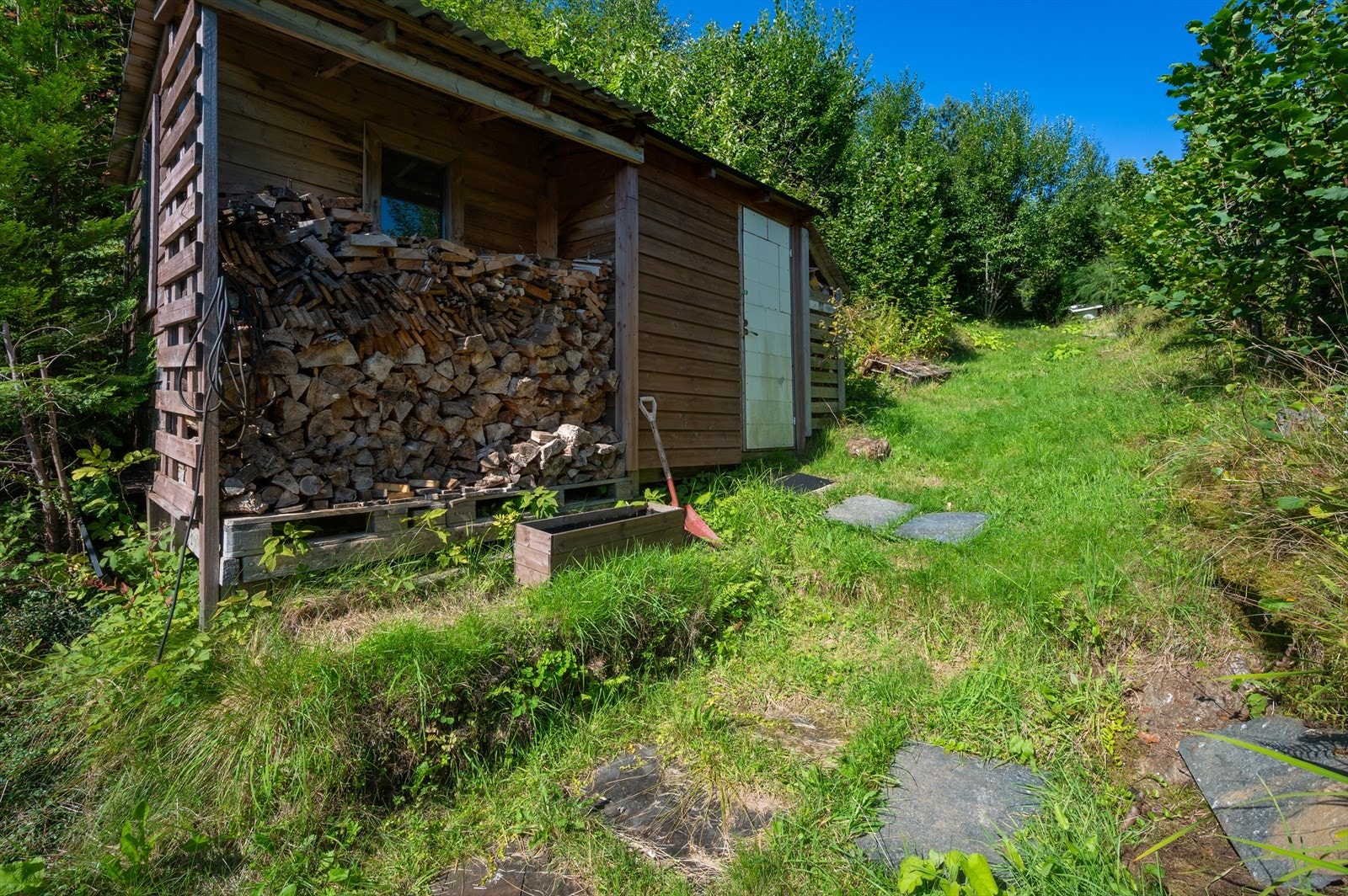 Hytten har to utvendige boder med plass til ved, tur- og fritidsutstyr Galleribilde