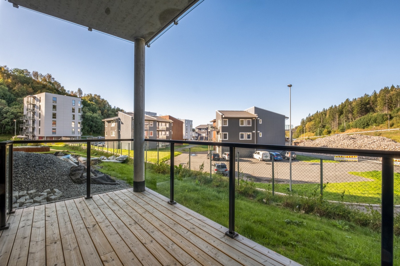 Overbygget markterrasse på 10 kvm med spaltegulv og gelender i glass og metall. Galleribilde