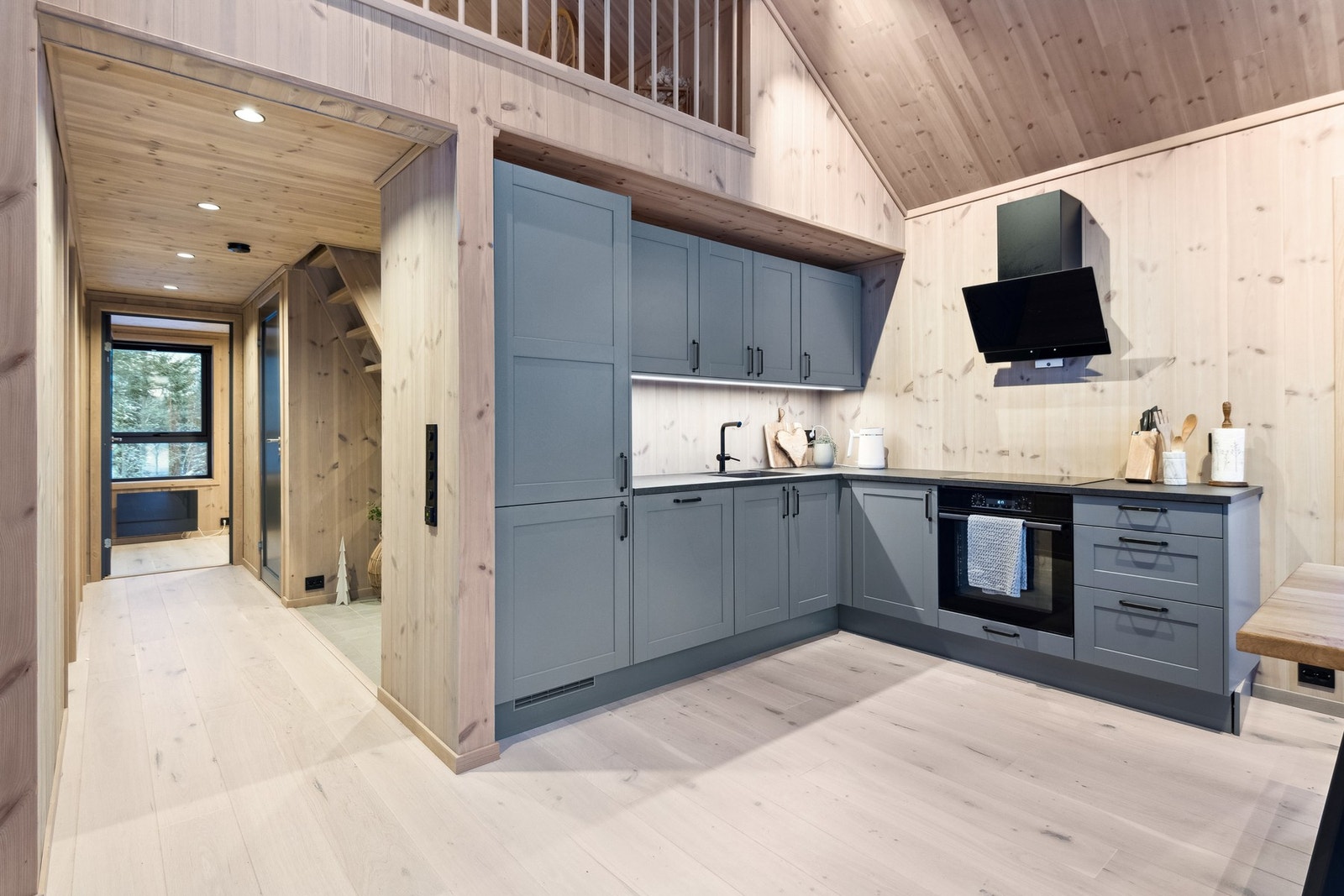 Moderne og stilrent kjøkken med integrert oppvaskmaskin, komfyr, platetopp og kombiskap kjøl/frys. Galleribilde