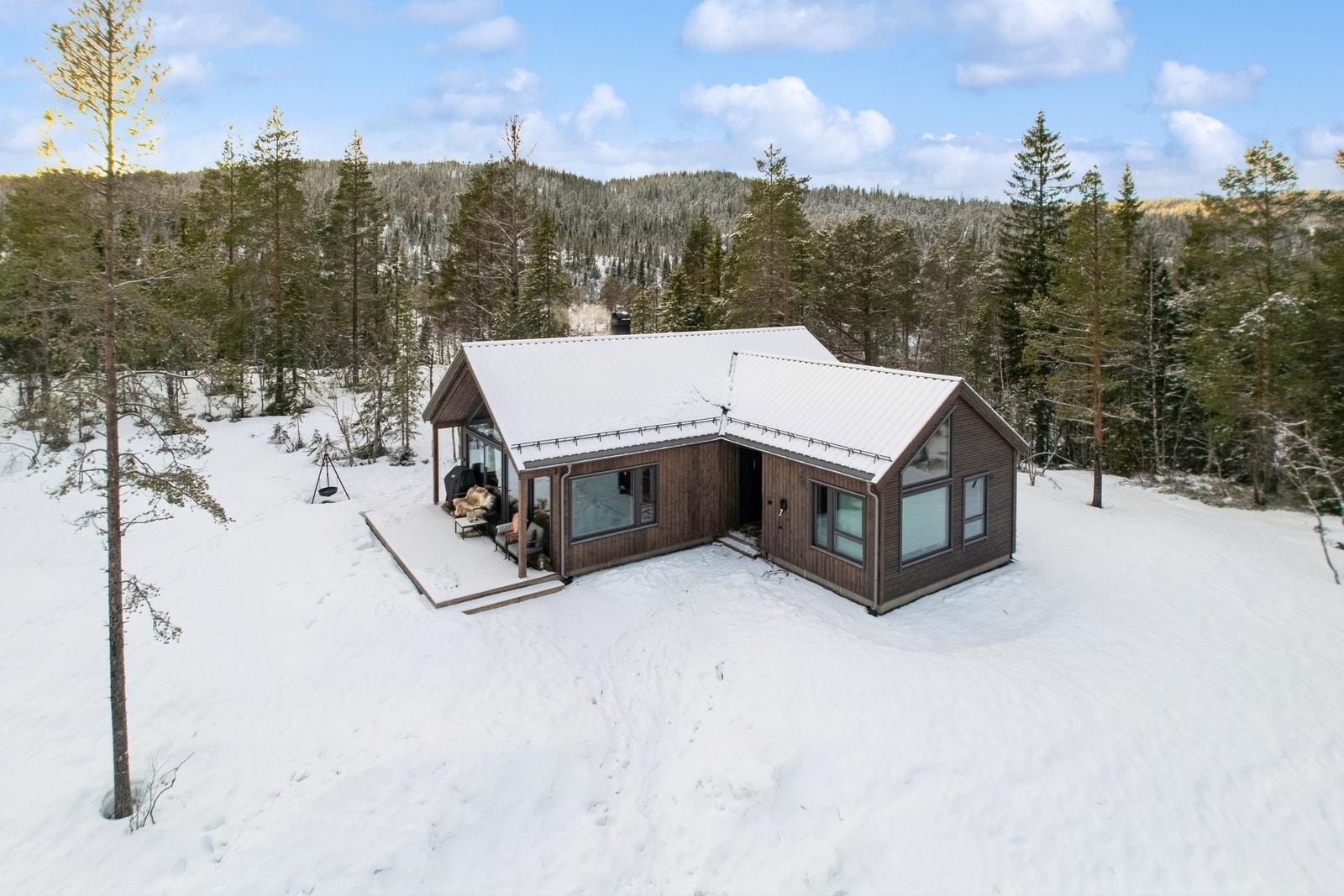 Parkering utendørs rett ved hytta. Det er montert elbillader som medfølger i handelen. Galleribilde