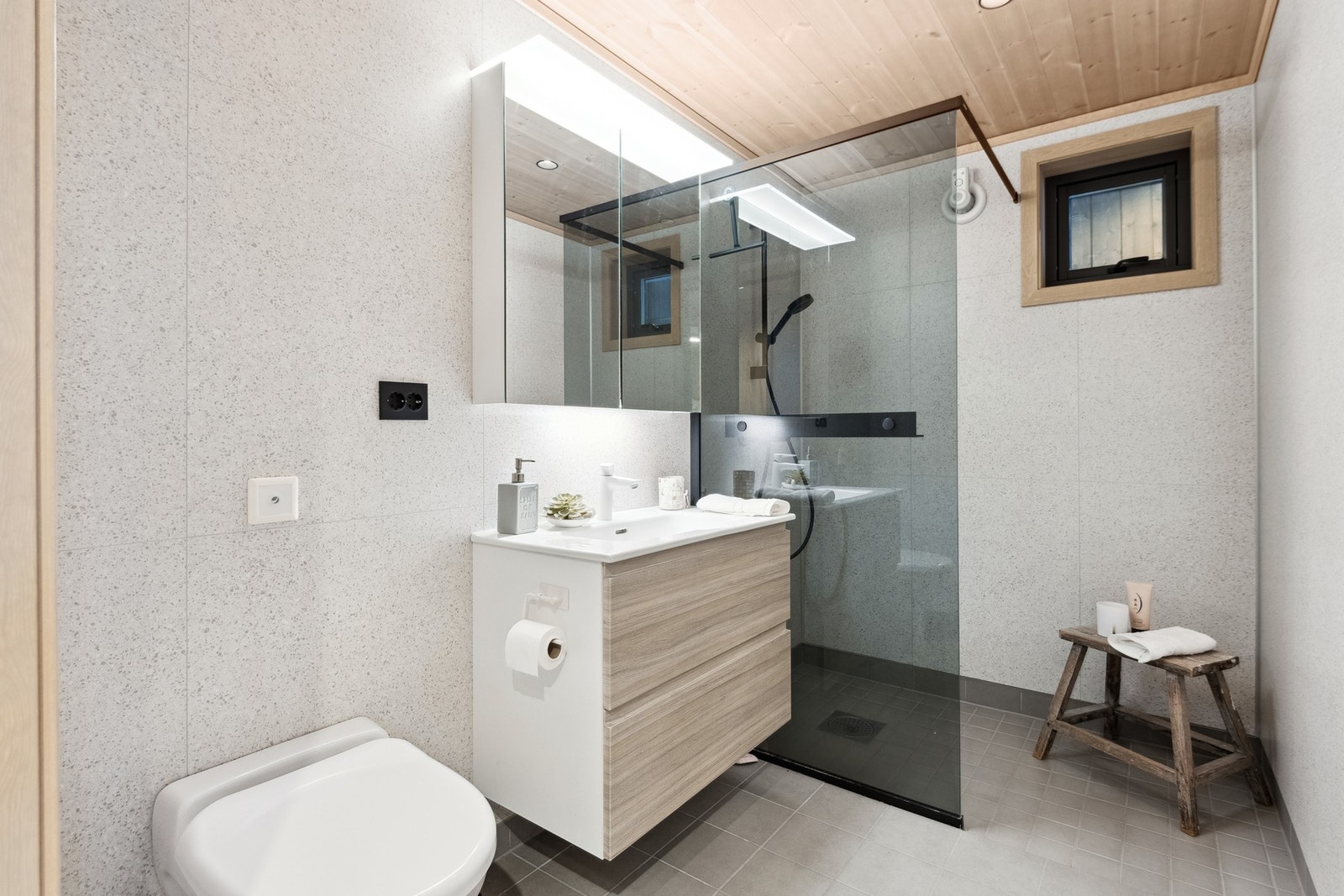 Flislagt bad med varmekabler i gulv. Vegghengt Jets Vacuum toalett og dusjhjørne. Galleribilde