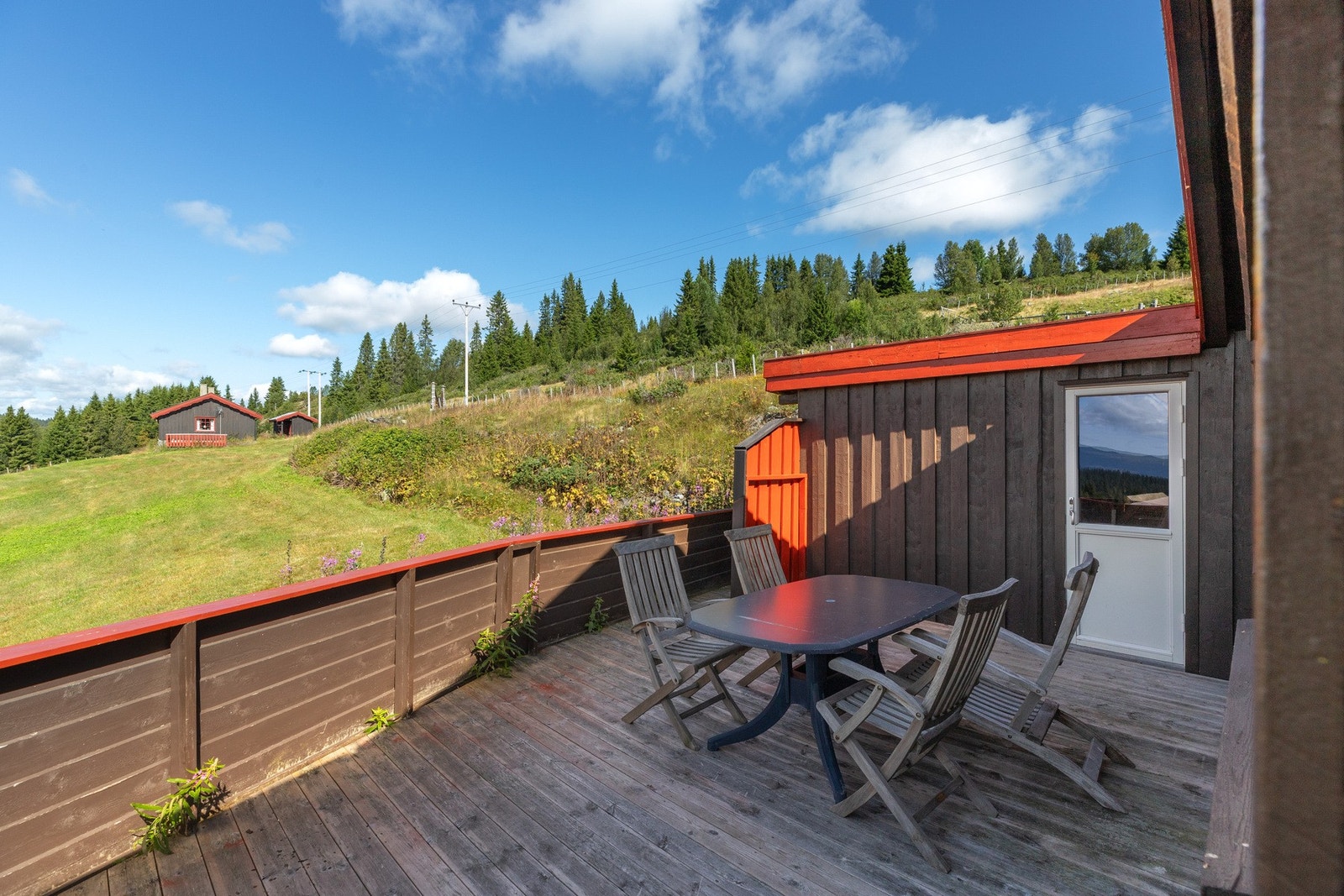 Videre til en åpen terasse med plass til utemøbler. Her kan fine soldager nytes med flott utsikt. I tilknytning til terassen er det en utvendig uisolert med utedo. Galleribilde