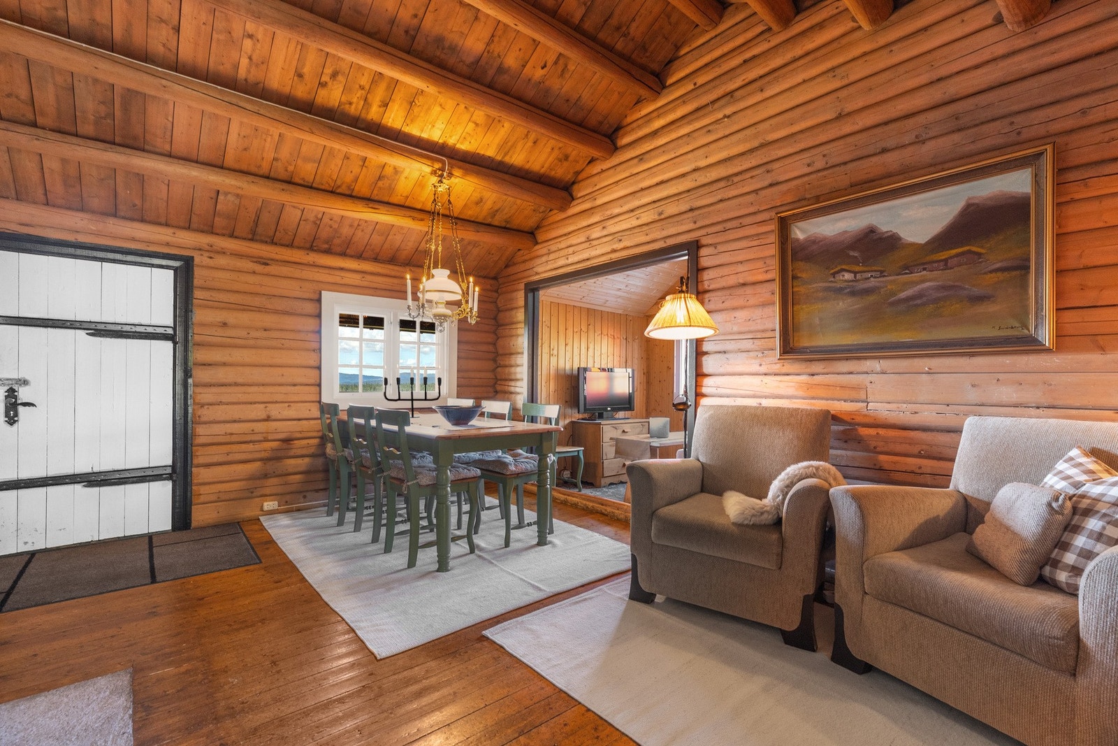 God takhøyde og tømmeråser i himlingen gir et fint hyttepreg Galleribilde