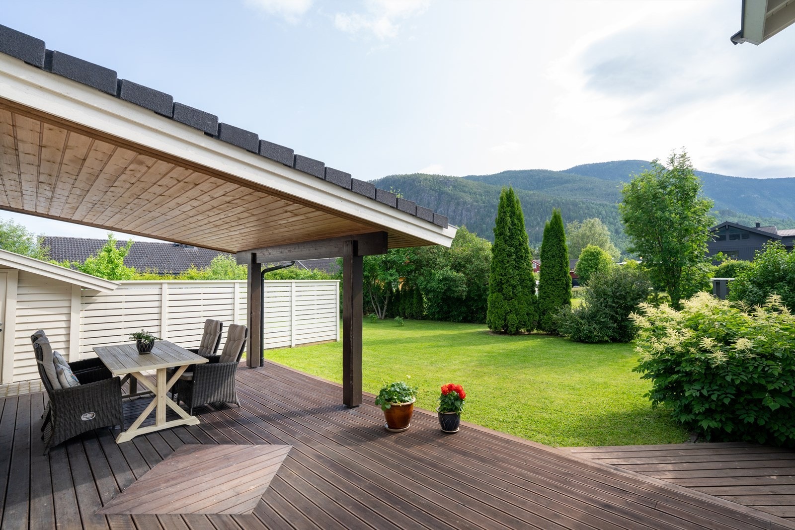 Fine utearealer med terrassegulv med og uten tak, og videre til terreng med plen og beplantning. Galleribilde