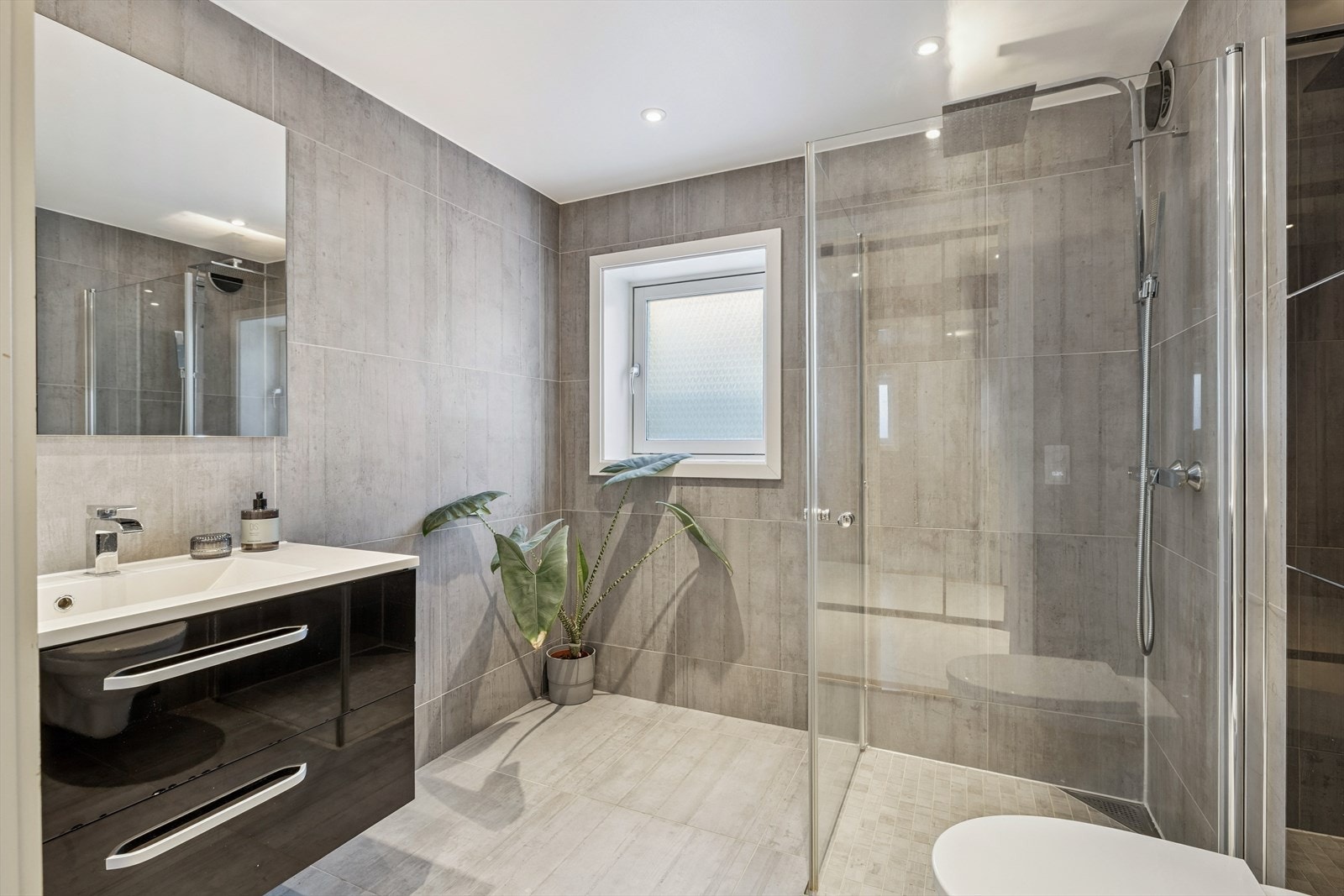 Delikat flislagt baderom med moderne innredning. Galleribilde