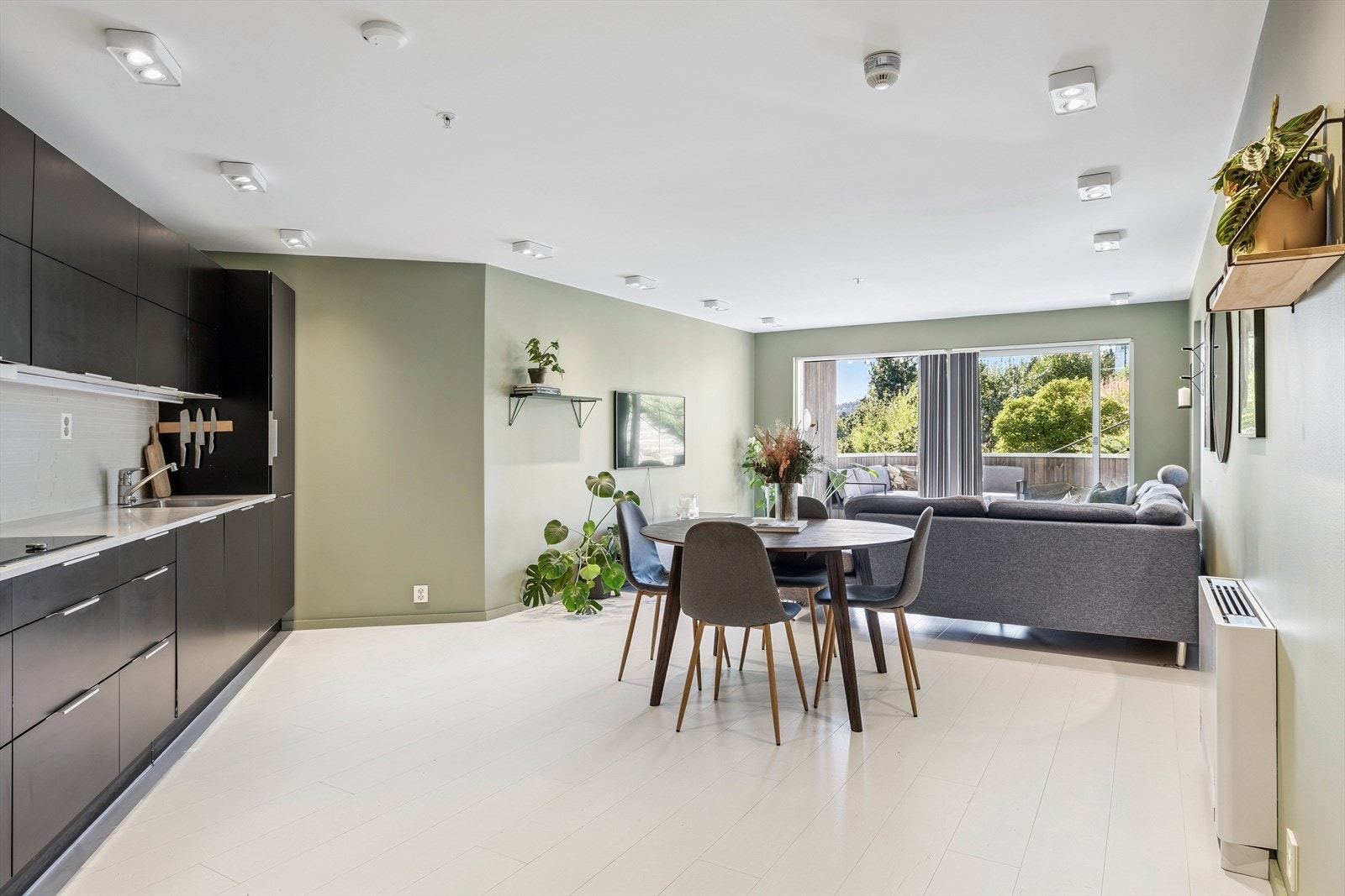 Åpen løsning mellom stue og kjøkken. Det er god plass til å møblere med sofagruppe og spisebord. Galleribilde