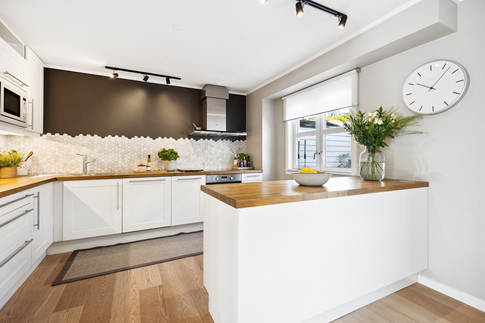 Kjøkkenet har god skap- og benkeplass, samt Evoline nedfellbar kontaktsøyle i kjøkkenøyen. Flisene over benkeplaten tilfører både eleganse og funksjonalitet. Galleribilde