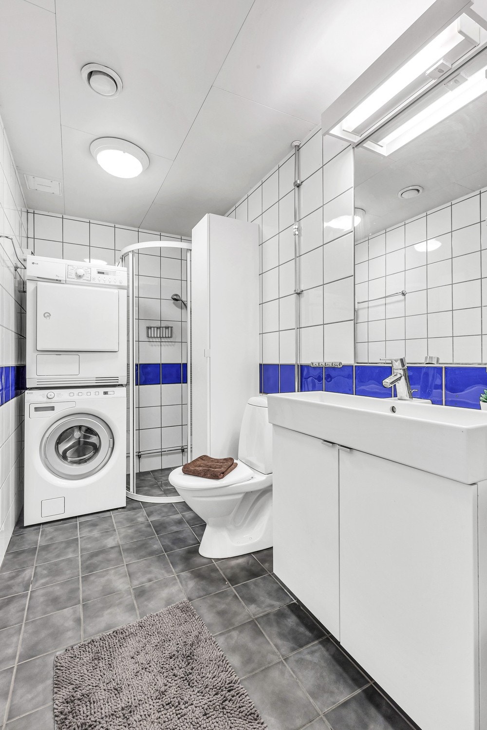 Flislagt bad, servant med underskapspeil og armatur med stikk. Opplegg med vaskemaskin/tørketrommel Galleribilde