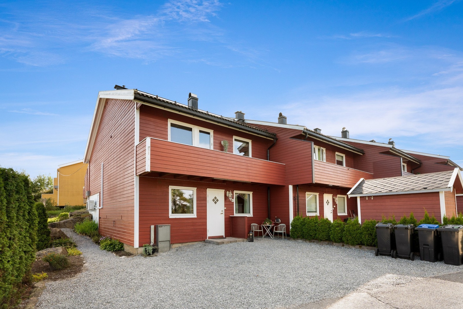 Pent overbygd inngangsparti med gruslagt adkomst. Parkering på utsiden av inngangen. Galleribilde