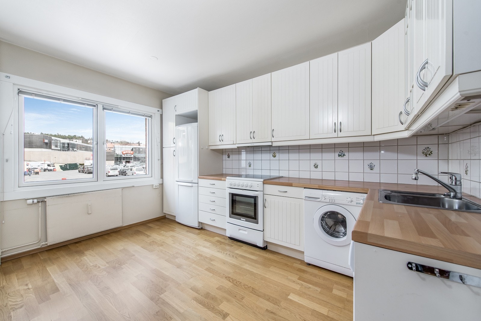 Godt planlagt kjøkkeninnredning med mye skap og benkeplass. Mulighet for fin spiseplass ved vinduet. Galleribilde