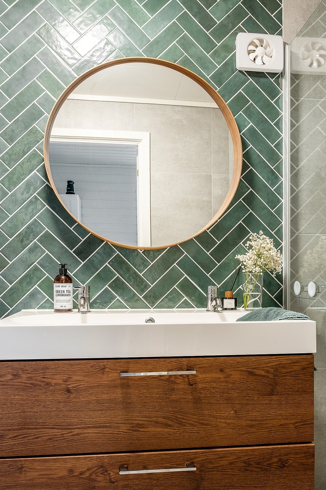 Deler av veggen bak baderomsinnredningen er flislagt med dekorfliser. Galleribilde