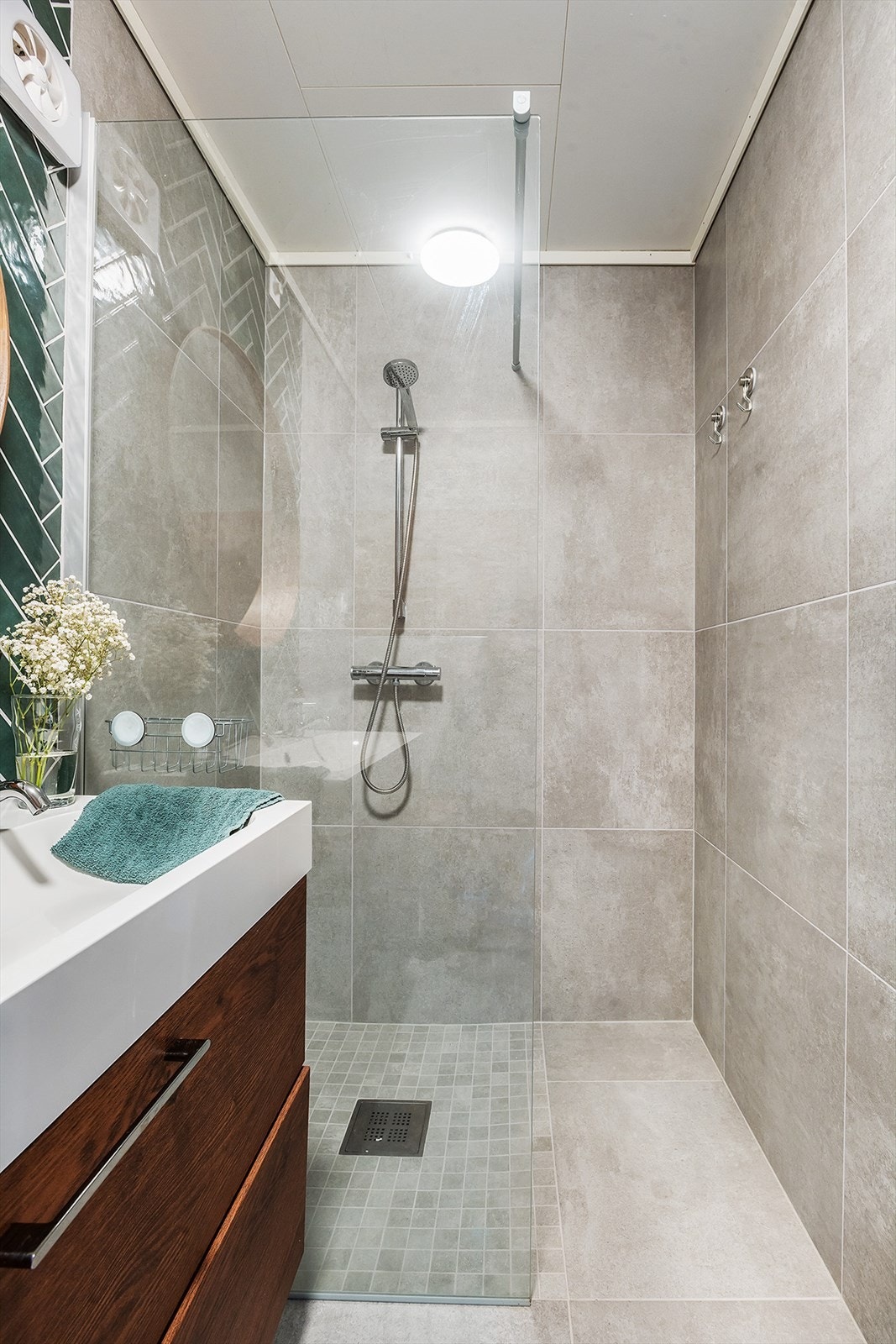 Badet i underetasjen er stilfult innredet med helfliset gulv og vegger - Baderomsinnredningen har dobbeltservant og ekstra skapinnredning. Galleribilde