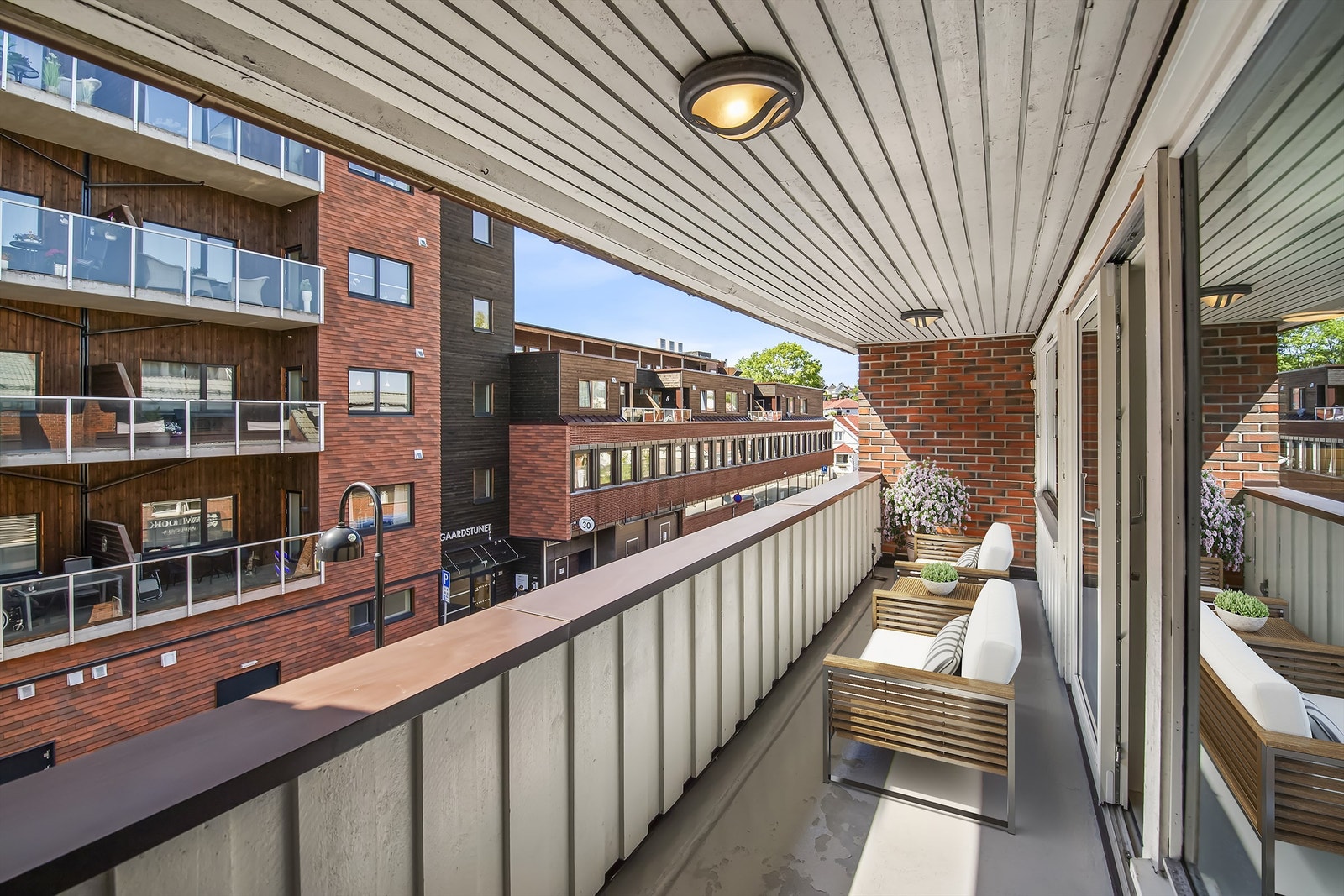 Overbygd balkong med plass til flere sittegrupper Galleribilde