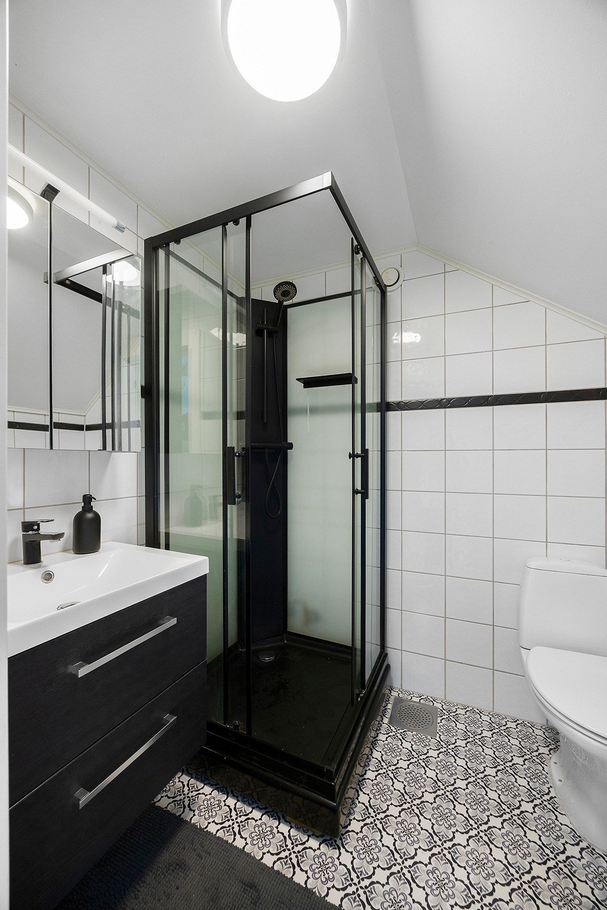 Praktisk og tiltalende baderom med toalett, servant med skuffeseksjon under og med speilskap over, samt dujskabinett. Galleribilde