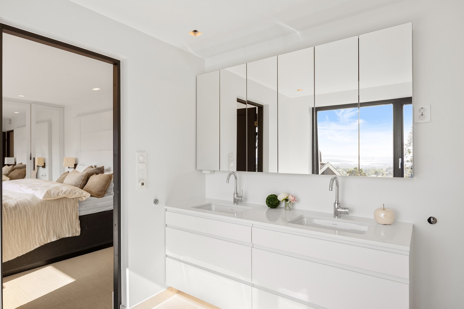 Her finner du badekar med tappekran og dusjslange, dusjhjørne med innfellbare dusjdører, benkeplate med dobbel servant og svingbare blandebatterier, veggmontert skap med speilfront og veggmontert toalett. Badet har mekanisk avtrekk. Galleribilde