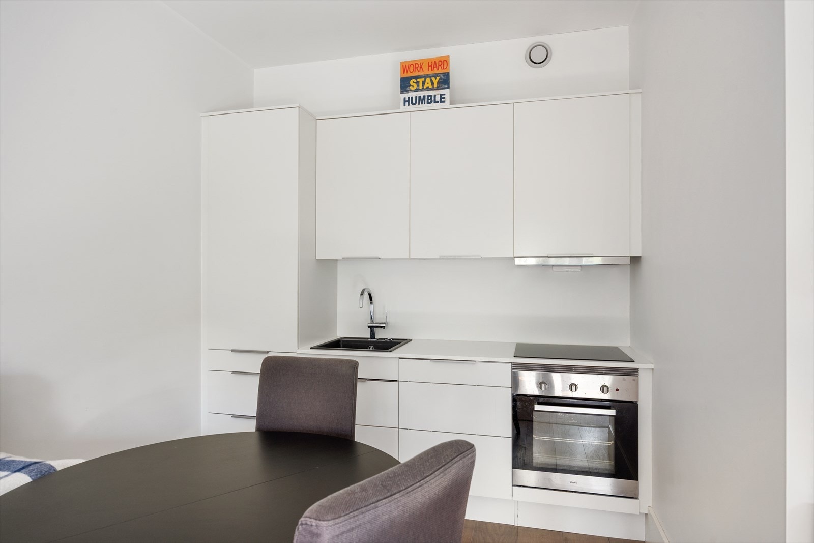 Hybel: moderne kjøkken fra 2018 med laminert benkeplate og oppvaskkum med svingbart blandebatteri. Integrerte hvitevarer inkluderer kjøleskap, oppvaskmaskin, stekeovn og platetopp med kullfiltervifte. Galleribilde