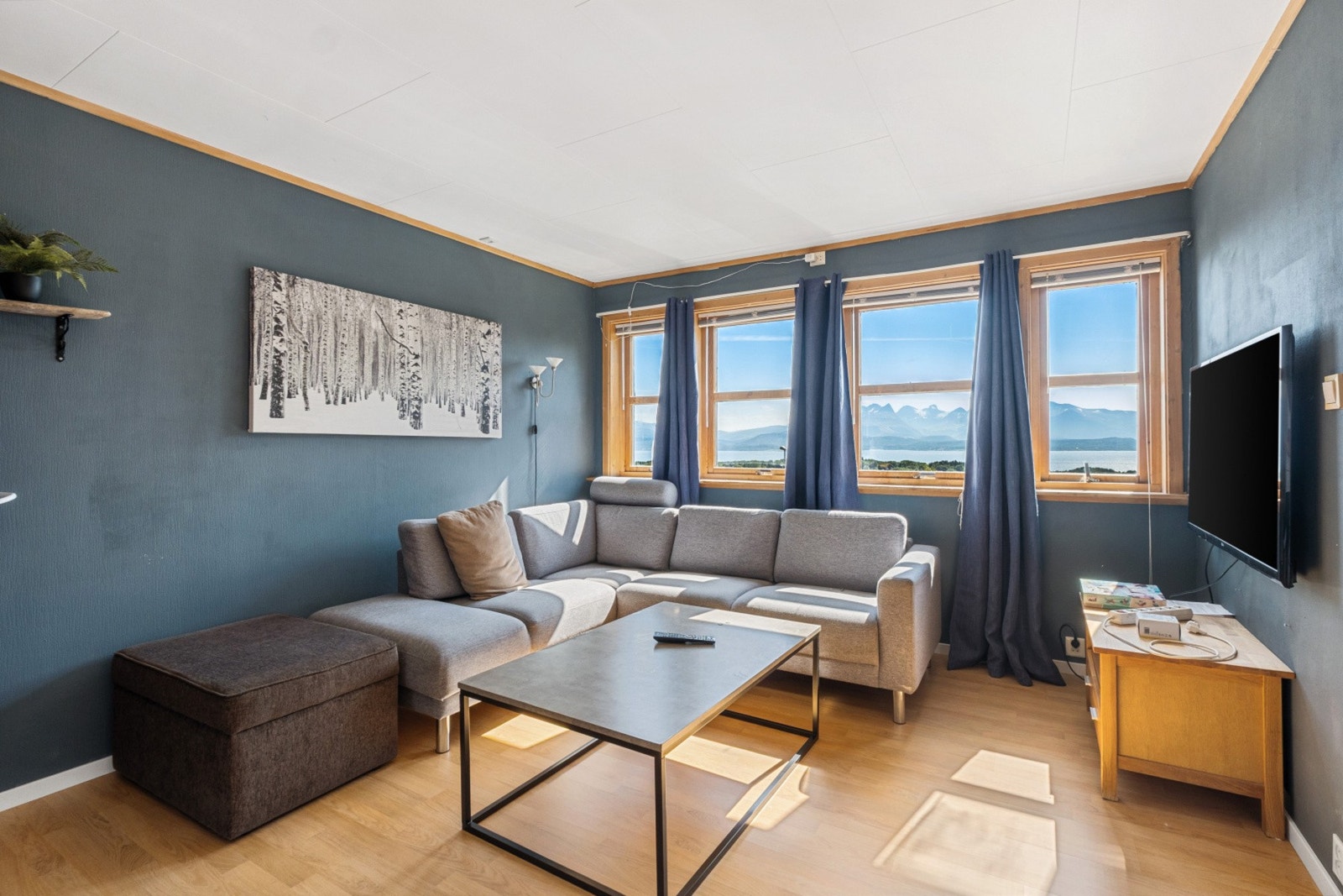 Ned trappen åpner hovedstuen seg - med panoramavinduer som rammer inn fjellformasjoner og glitrende havlinje. Galleribilde