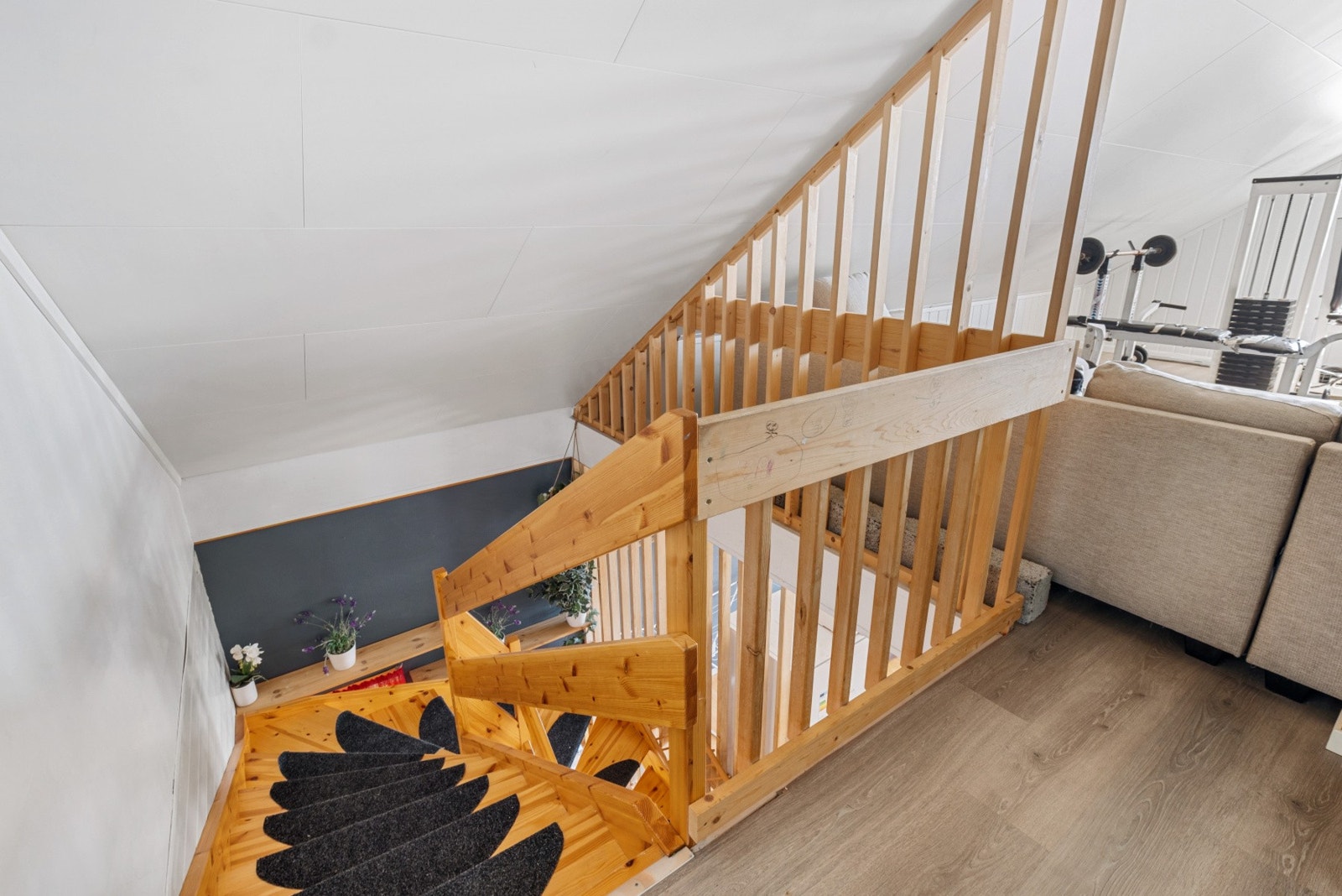 Fra loftet leder en svingtrapp i heltre ned - et solid og plassbesparende bindeledd mellom etasjene. Galleribilde