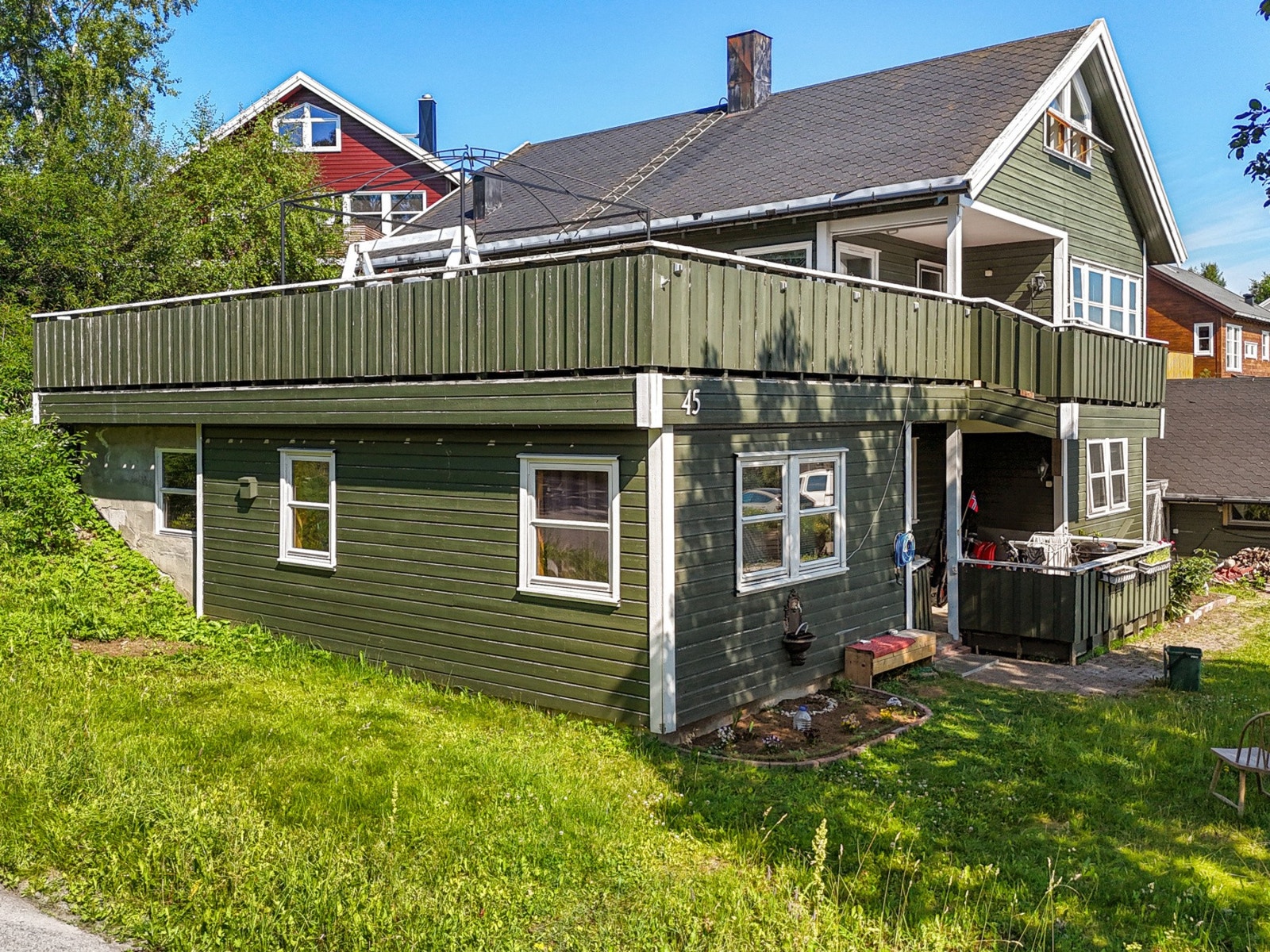 Fasaden vender ut mot grøntarealer og skjermet inngang - med tydelig adskilt hoveddel og underliggende utleieenhet. Galleribilde