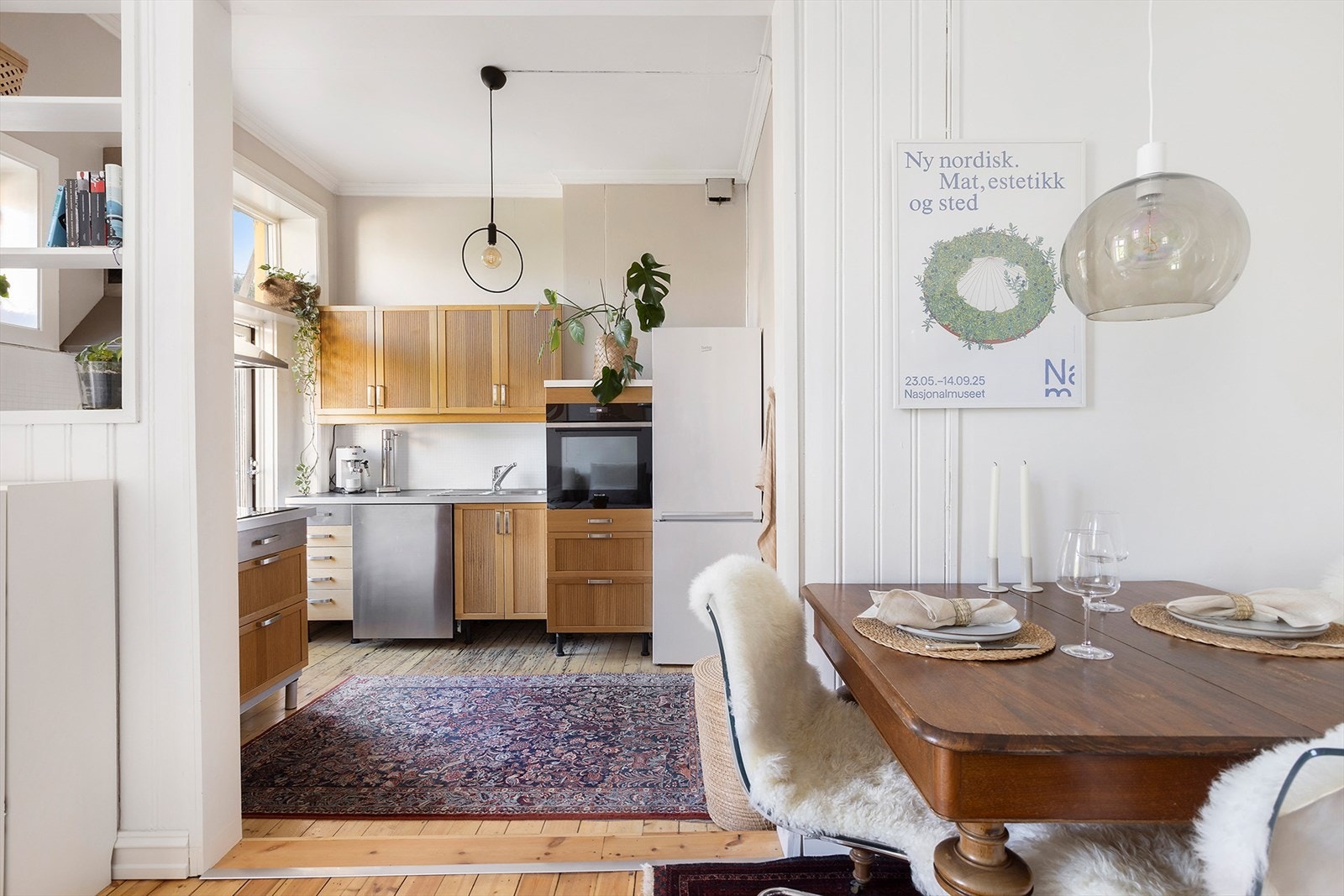 Kjøkkenet er praktisk plassert i en halvåpen løsning mot stuen, med moderne innredning, slette fronter og benkeplate i laminat. Galleribilde