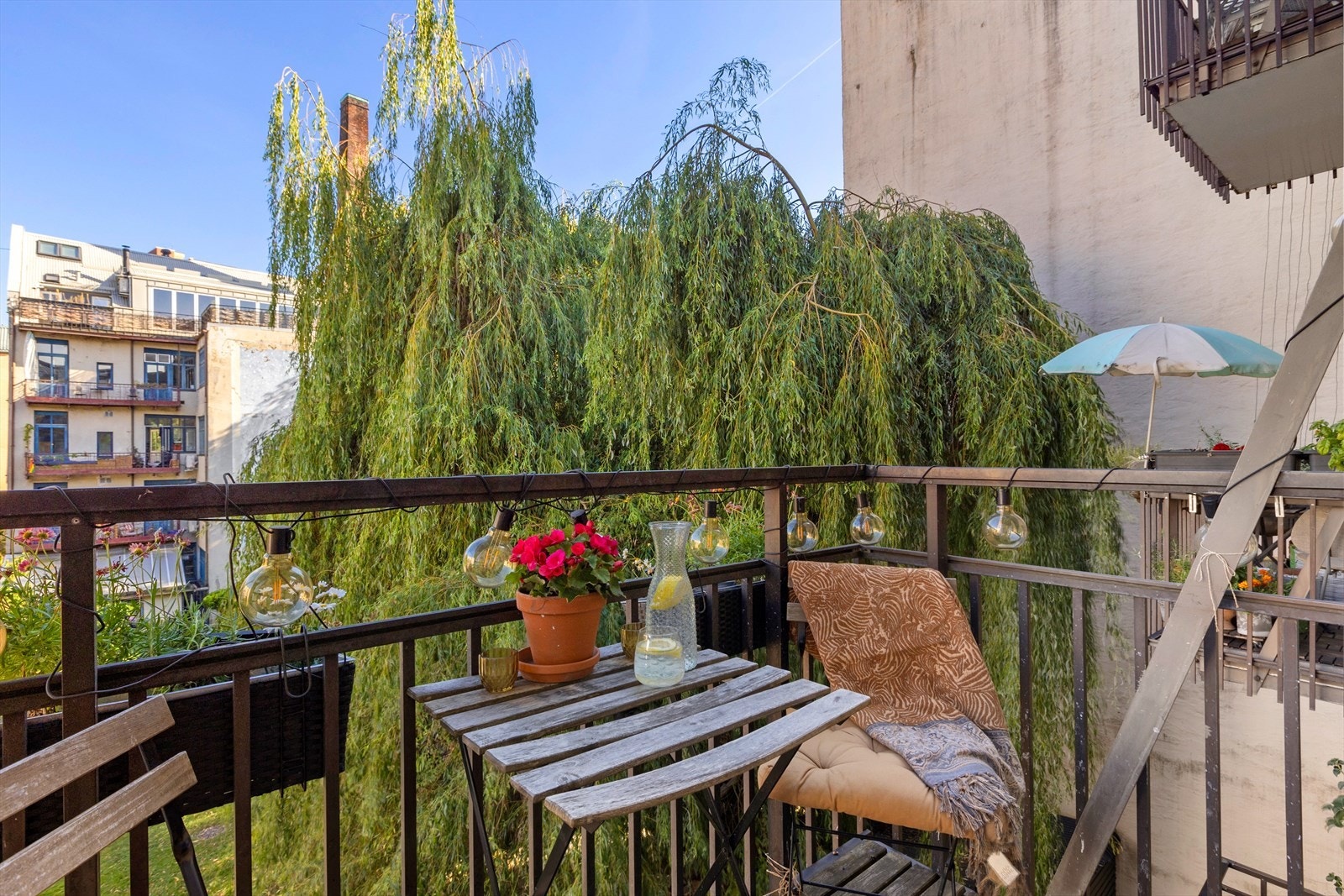 Balkongen fremstår innbydende med tredekke og moderne metallrekkverk. Galleribilde