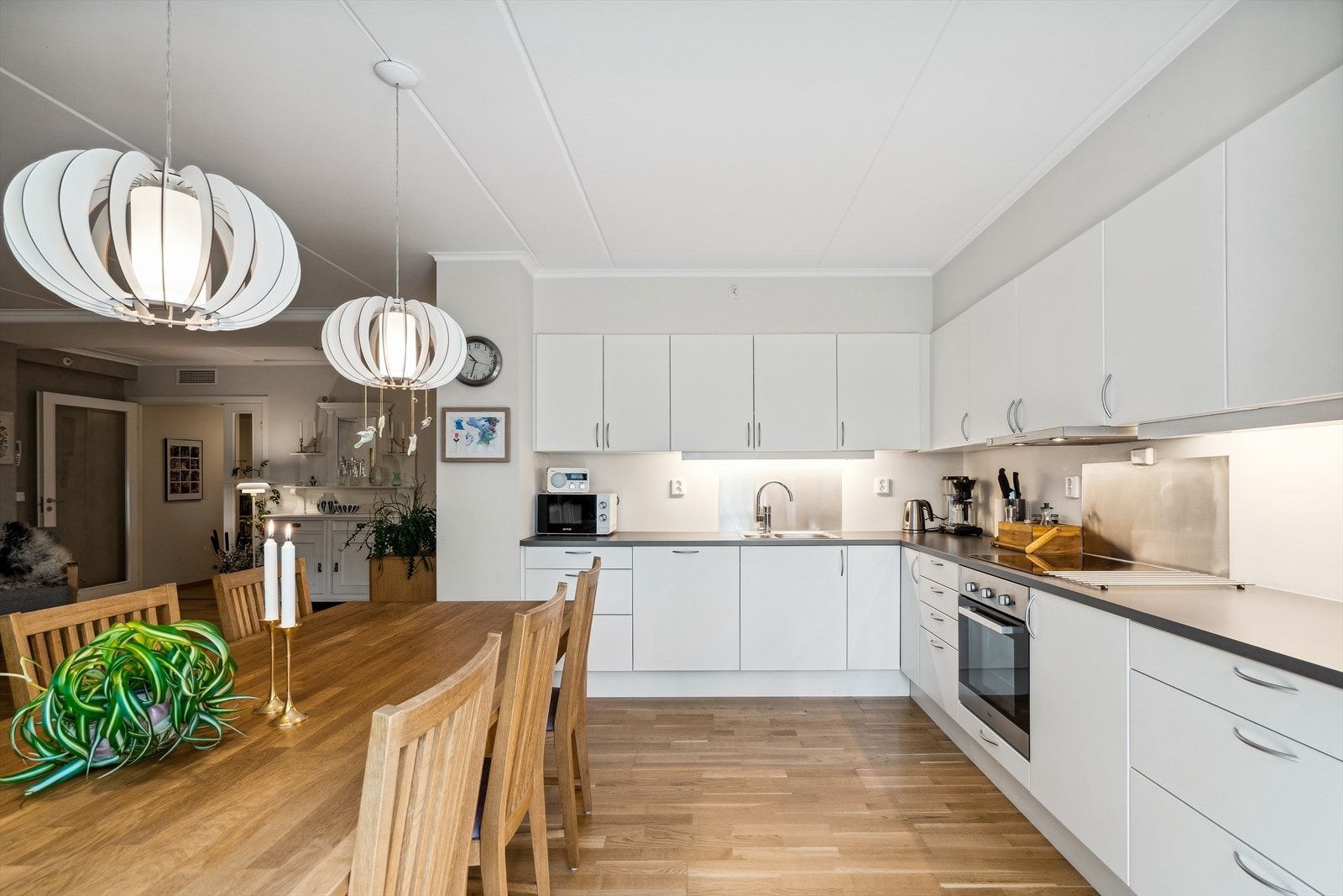 Fin kjøkkeninnredning med integrert oppvaskmaskin, platetopp og stekovn. Galleribilde