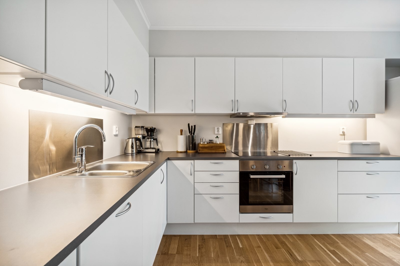 Kjøkkeninnredning med godt med skap- og benkeplass. Galleribilde