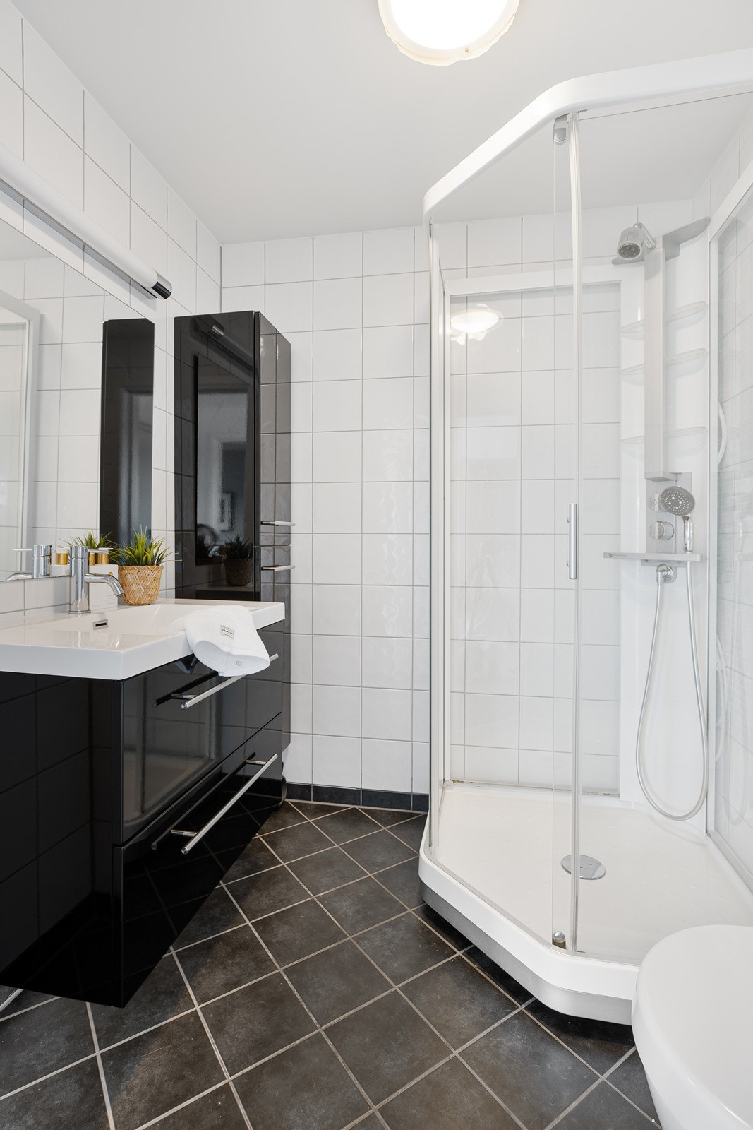 Flislagt bad med varmekabler i gulv. Innredet med vegghengt toalett, dusjkabinett, vegghengt servant med skuffesystem og vegghengt skap Galleribilde