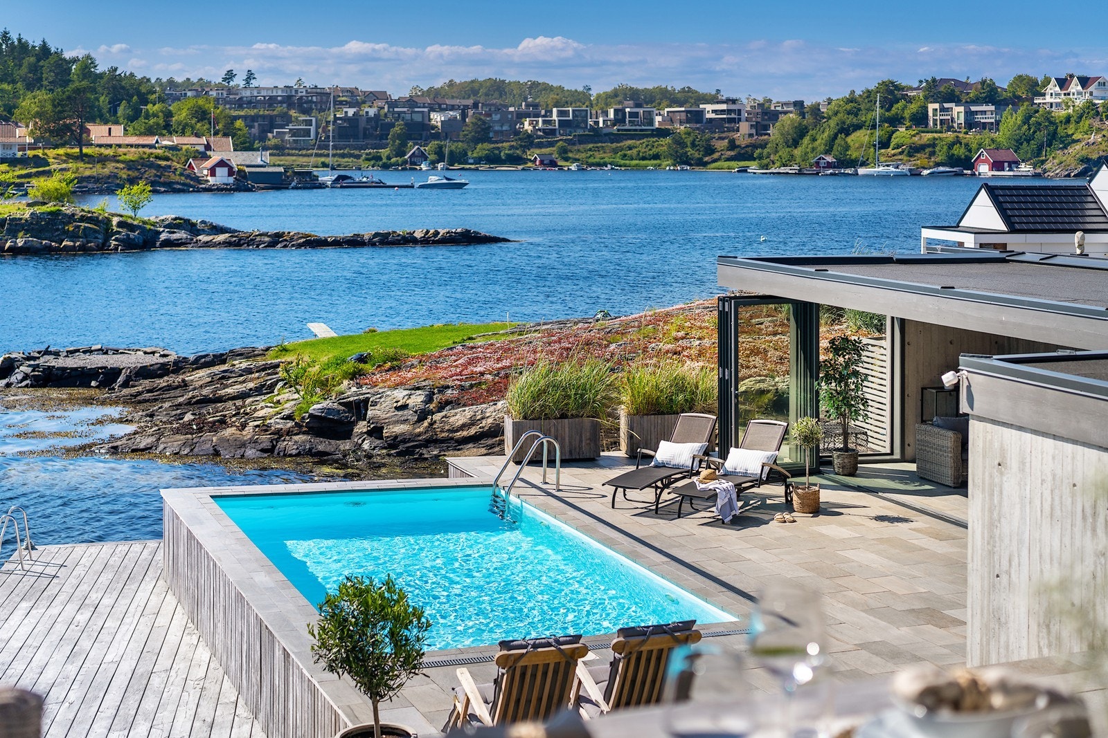 Fra spisegruppen på terrassen har man god utsikt over basseng- og bryggeområde Galleribilde