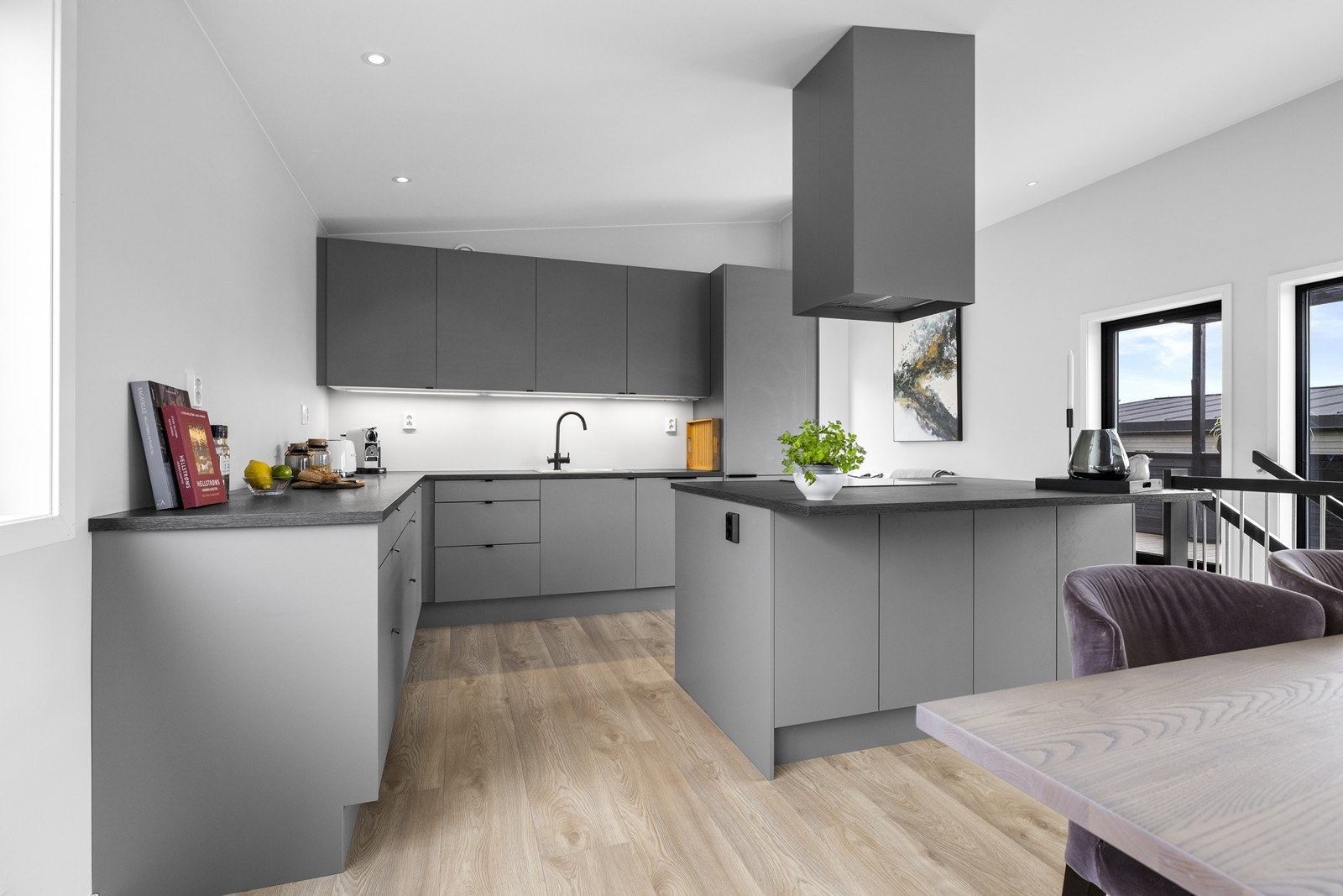 Kjøkkenet er pent og moderne med grå glatte fronter og benkeplate i laminat. Galleribilde